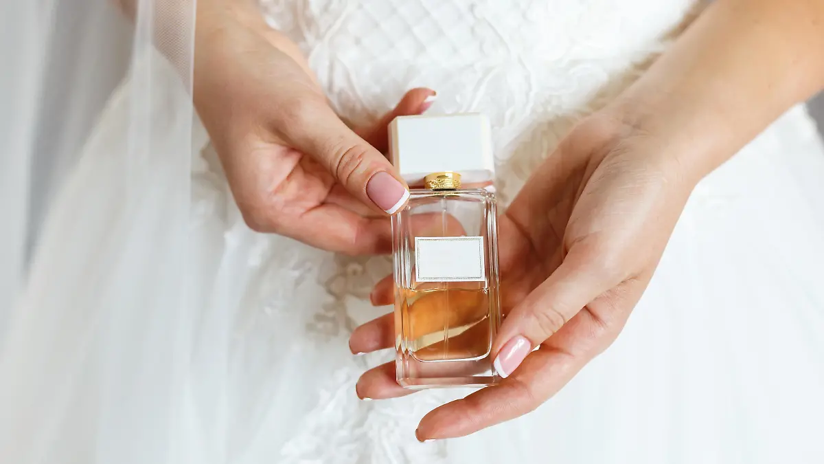 Woman in white dress holding in hands parfum. Wedding bridal accessories and details, preparation for celebrating xkwx parfum, woman, fragrance, parfume, cosmetics, bride, wedding, accessories, applying, aroma, background, beautiful, beauty, bottle, brand, bridal, date, details, dress, elegance, elegant, expensive, femininity, fragrant, gentle, girl, glass, hand, hands, indoor, luxury, Manicure, morning, perfume, pink, scent, sensual, smell, spray, toilette, white, wrist, young