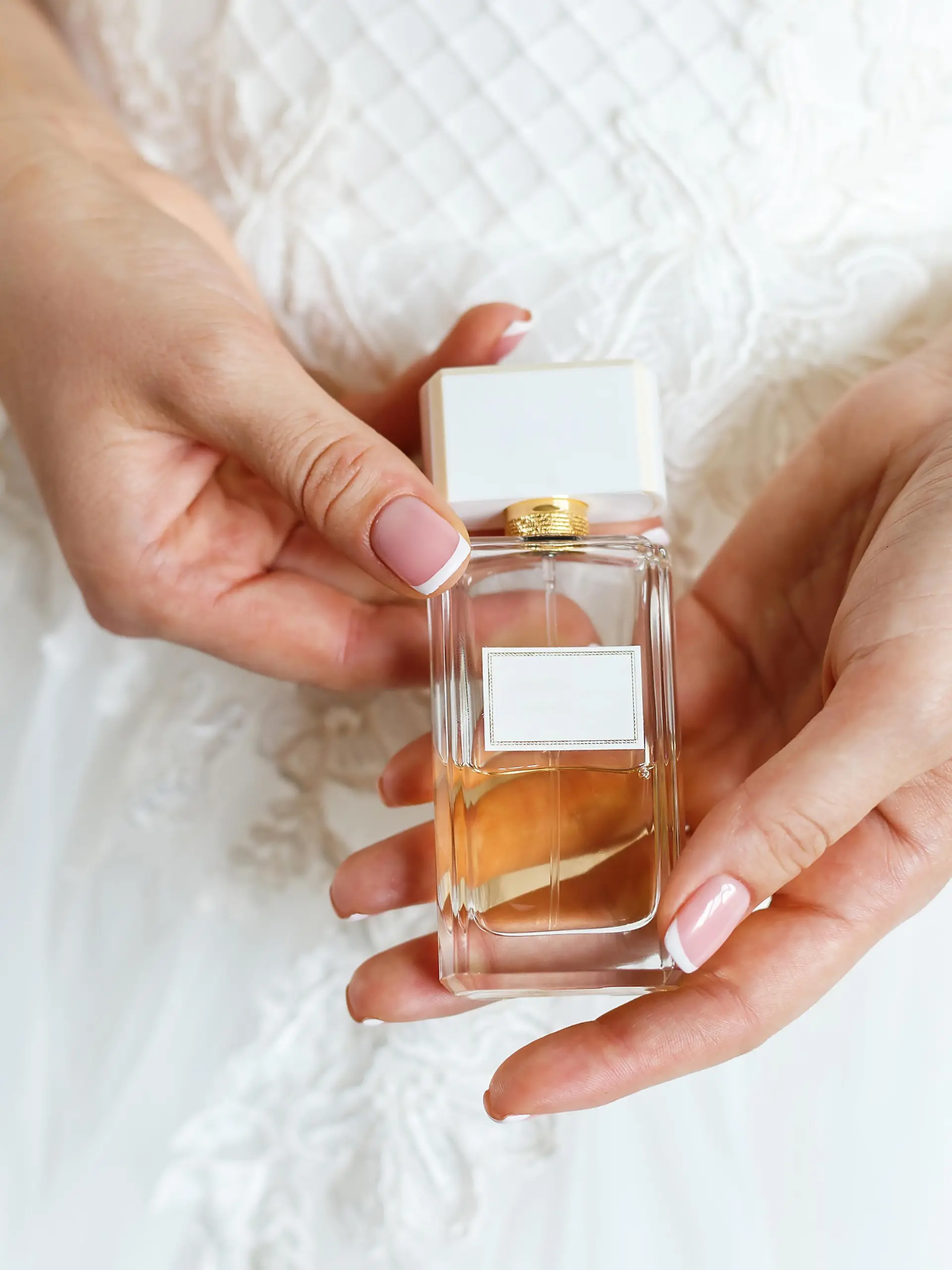 Woman  in  white  dress  holding  in  hands  parfum.  Wedding  bridal  accessories  and  details,  preparation  for  celebrating xkwx parfum,  woman,  fragrance,  parfume,  cosmetics,  bride,  wedding,  accessories,  applying,  aroma,  background,  beautiful,  beauty,  bottle,  brand,  bridal,  date,  details,  dress,  elegance,  elegant,  expensive,  femininity,  fragrant,  gentle,  girl,  glass,  hand,  hands,  indoor,  luxury,  Manicure,  morning,  perfume,  pink,  scent,  sensual,  smell,  spray,  toilette,  white,  wrist,  young