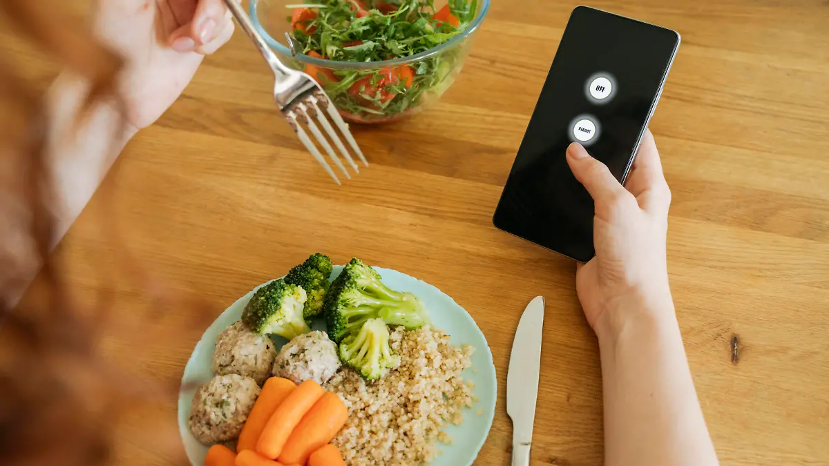 Young woman with food and smart phone sitting at dining table model released, Symbolfoto property released, OSF01773