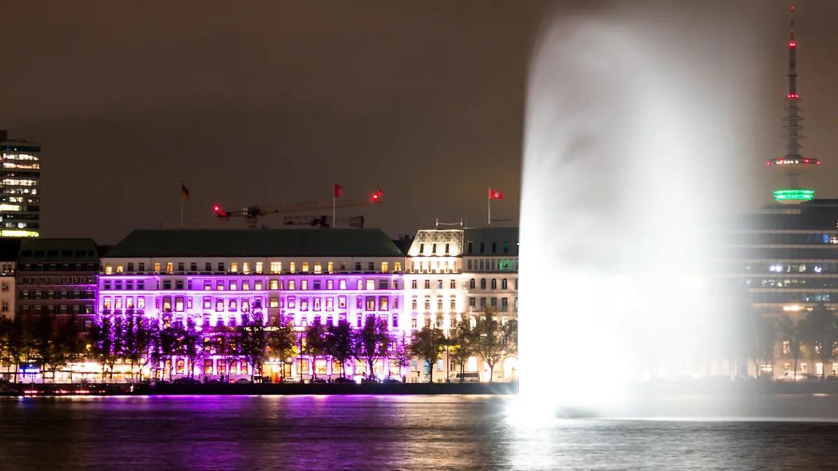 11.10.2023, Hamburg: Das Hotel "Vier Jahreszeiten" an der Binnenalster ist während einer Aktion der Organisation "Plan International" zum Weltmädchentag in pink beleuchtet. Foto: Daniel Bockwoldt/dpa +++ dpa-Bildfunk +++