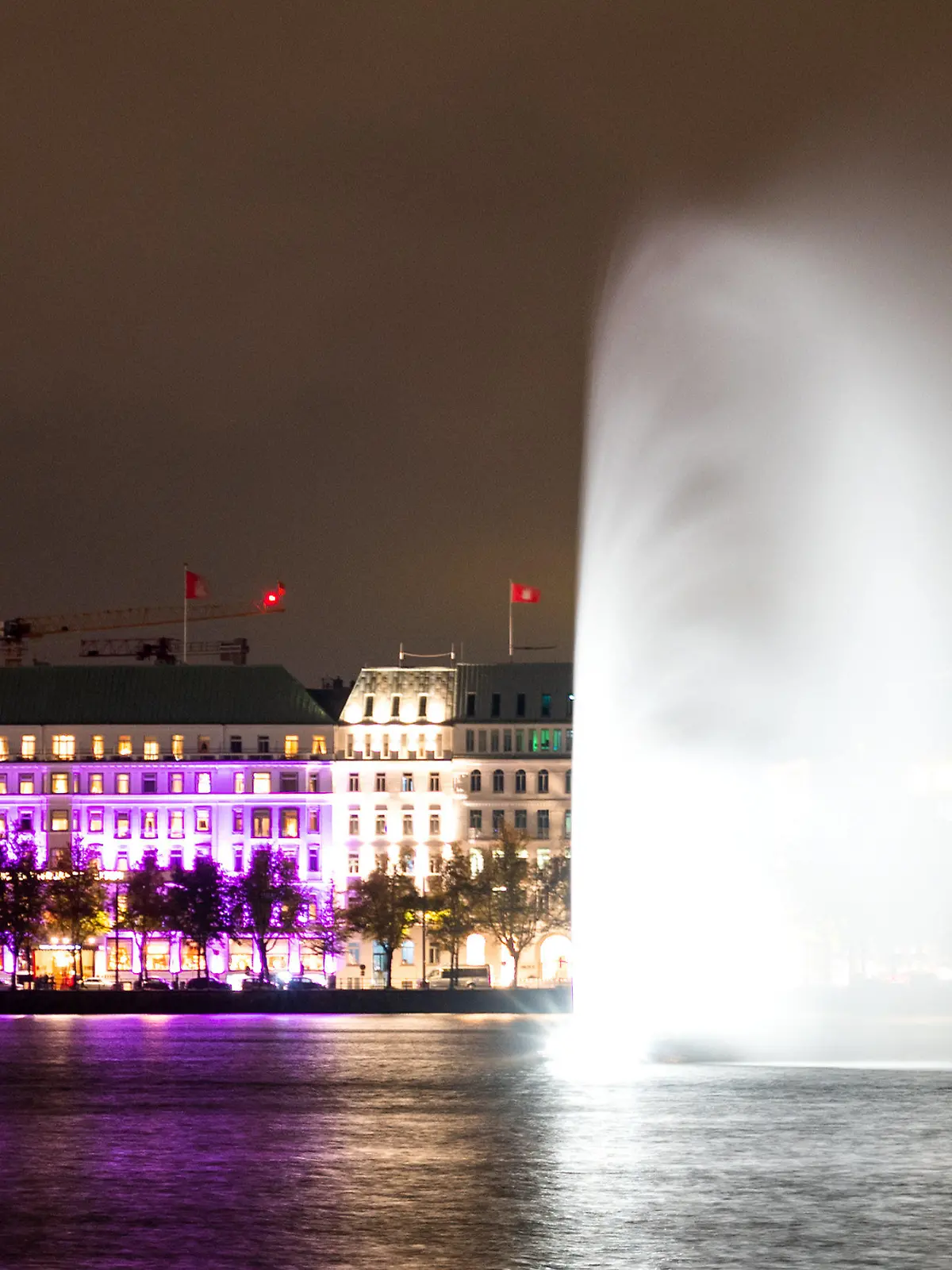 11.10.2023, Hamburg: Das Hotel "Vier Jahreszeiten" an der Binnenalster ist während einer Aktion der Organisation "Plan International" zum Weltmädchentag in pink beleuchtet. Foto: Daniel Bockwoldt/dpa +++ dpa-Bildfunk +++