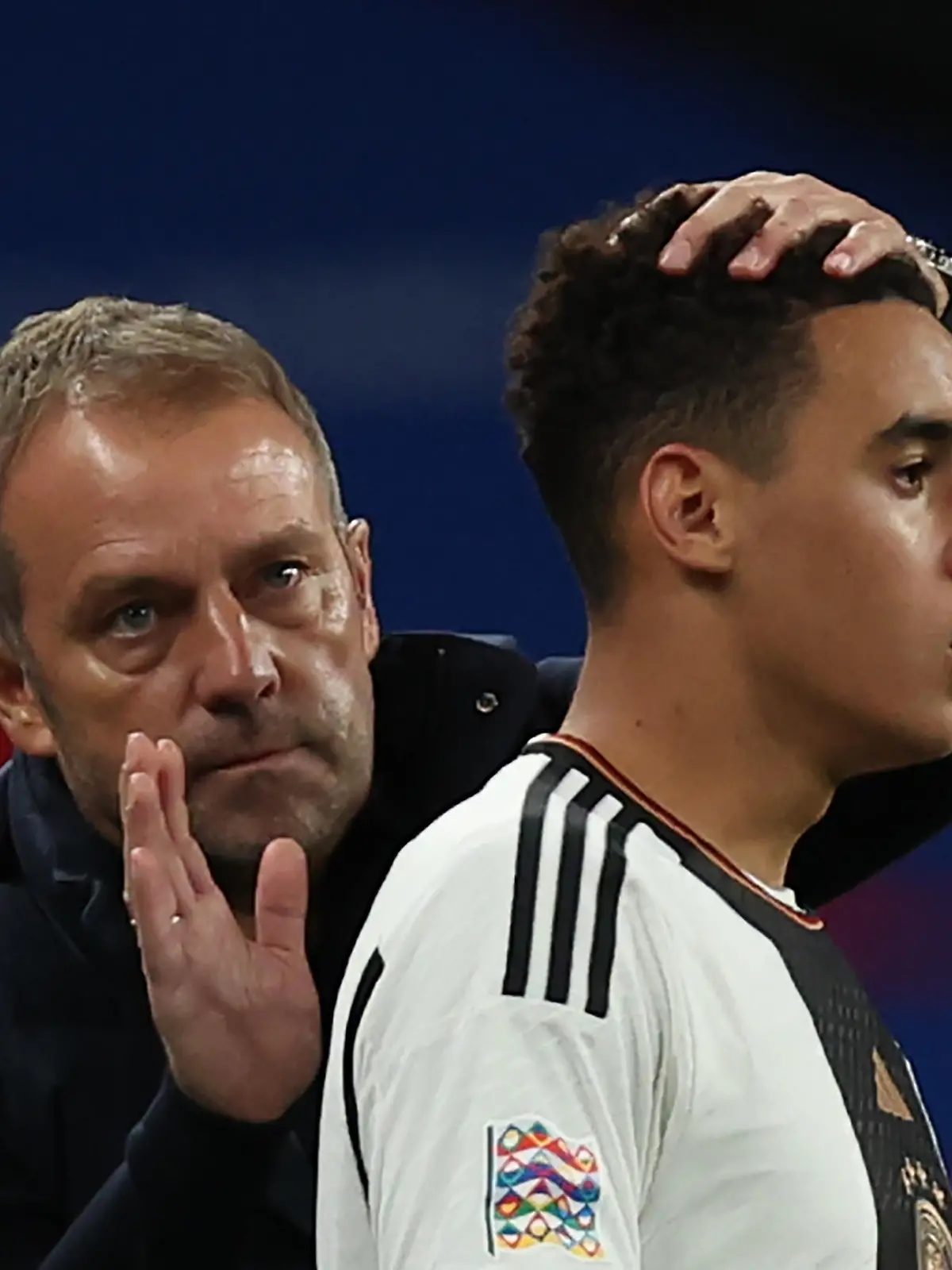 ARCHIV - 26.09.2022, Großbritannien, London: Fußball: Nations League A, England - Deutschland, Gruppenphase, Gruppe 3, 6. Spieltag im Wembley Stadion, Bundestrainer Hansi Flick tröstet Jamal Musiala während des Spiels. (zu dpa: «Musiala vor WM-Start: «Mindset, den Pokal holen zu können»») Foto: Christian Charisius/dpa +++ dpa-Bildfunk +++