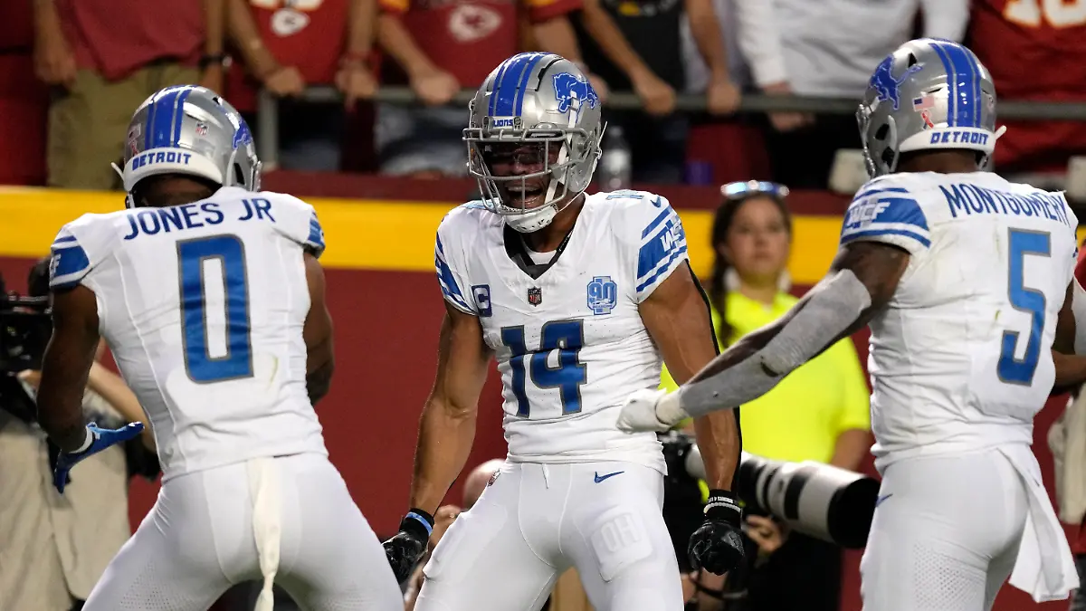 07.09.2023, USA, Kansas City: American Football: Profiliga NFL, Hauptrunde, Kansas City Chiefs - Detroit Lions, Arrowhead Stadium. Detroit Lions Wide Receiver Amon-Ra St. Brown (14) wird nach einem Touchdown von seinen Teamkollegen Marvin Jones Jr. (0) und David Montgomery (5) beglückwünscht. Foto: Charlie Riedel/AP +++ dpa-Bildfunk +++