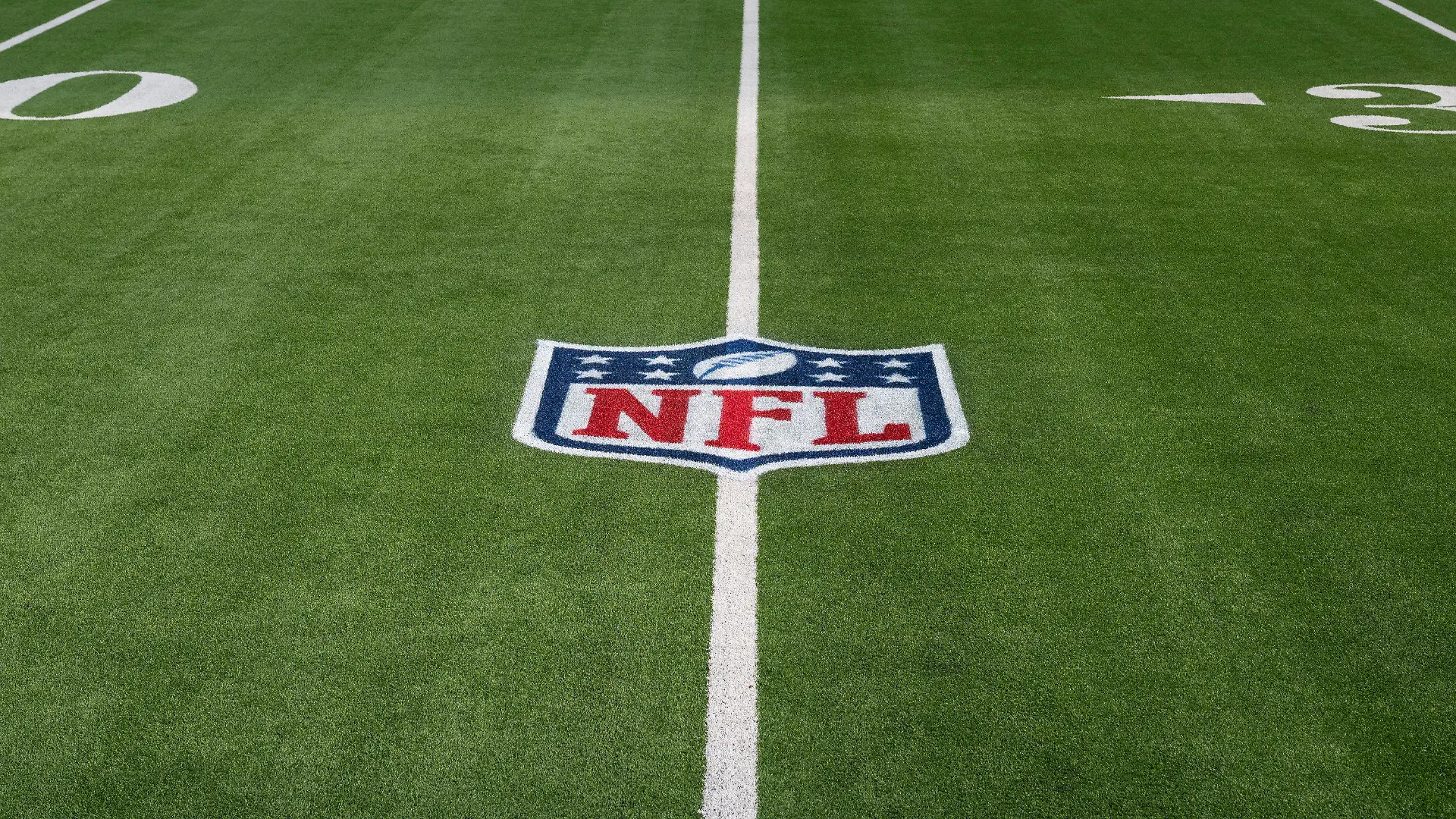 FILE - The NFL logo is shown on the artificial turf at So Fi Stadium in Inglewood, Calif. Dec. 5, 2021. The NFL Players Association wants the league to switch all its fields to natural grass, calling it the easiest decision the NFL can make to protect players. (AP Photo/John McCoy, File)