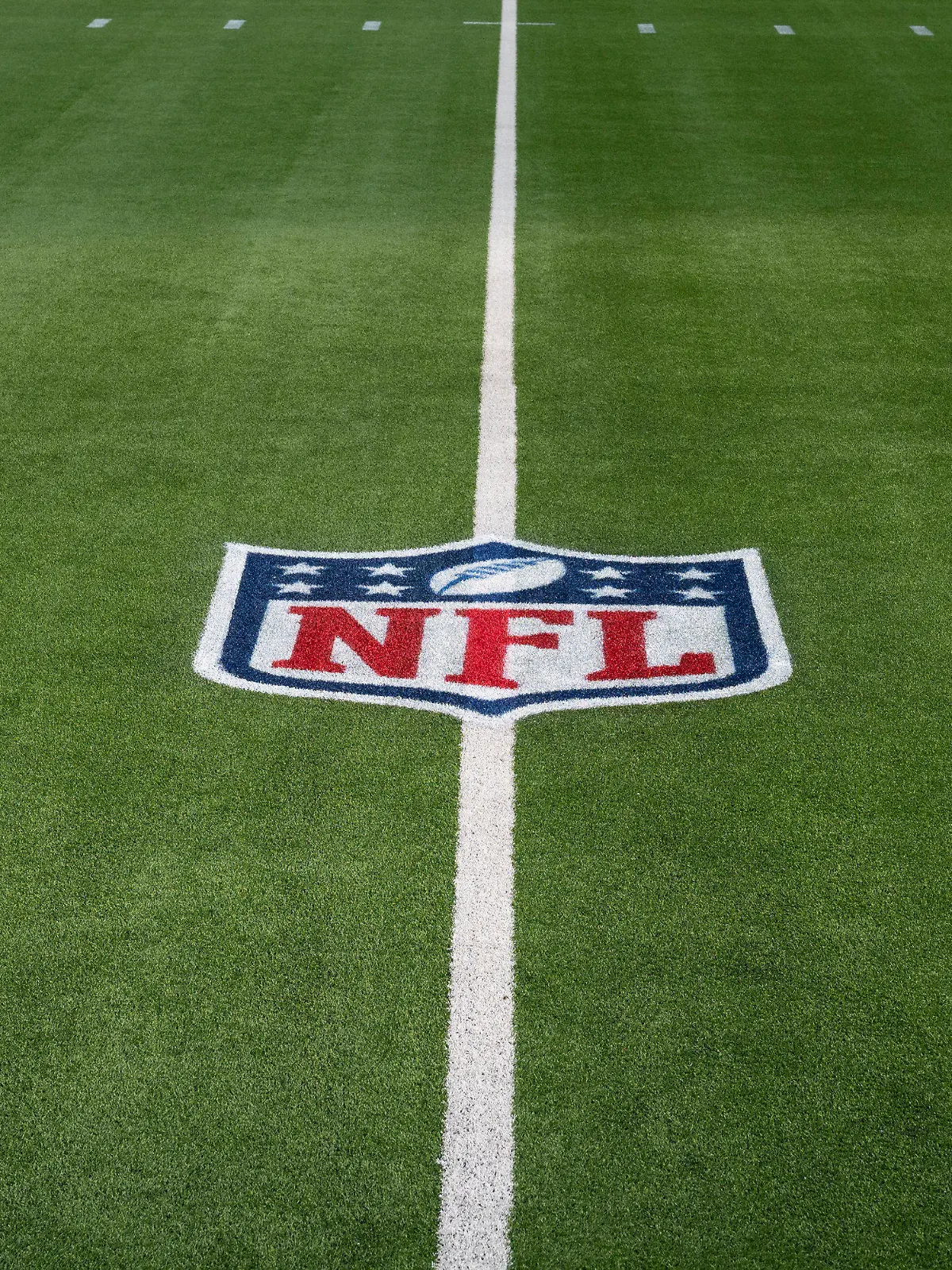 FILE - The NFL logo is shown on the artificial turf at So Fi Stadium in Inglewood, Calif. Dec. 5, 2021. The NFL Players Association wants the league to switch all its fields to natural grass, calling it the easiest decision the NFL can make to protect players. (AP Photo/John McCoy, File)