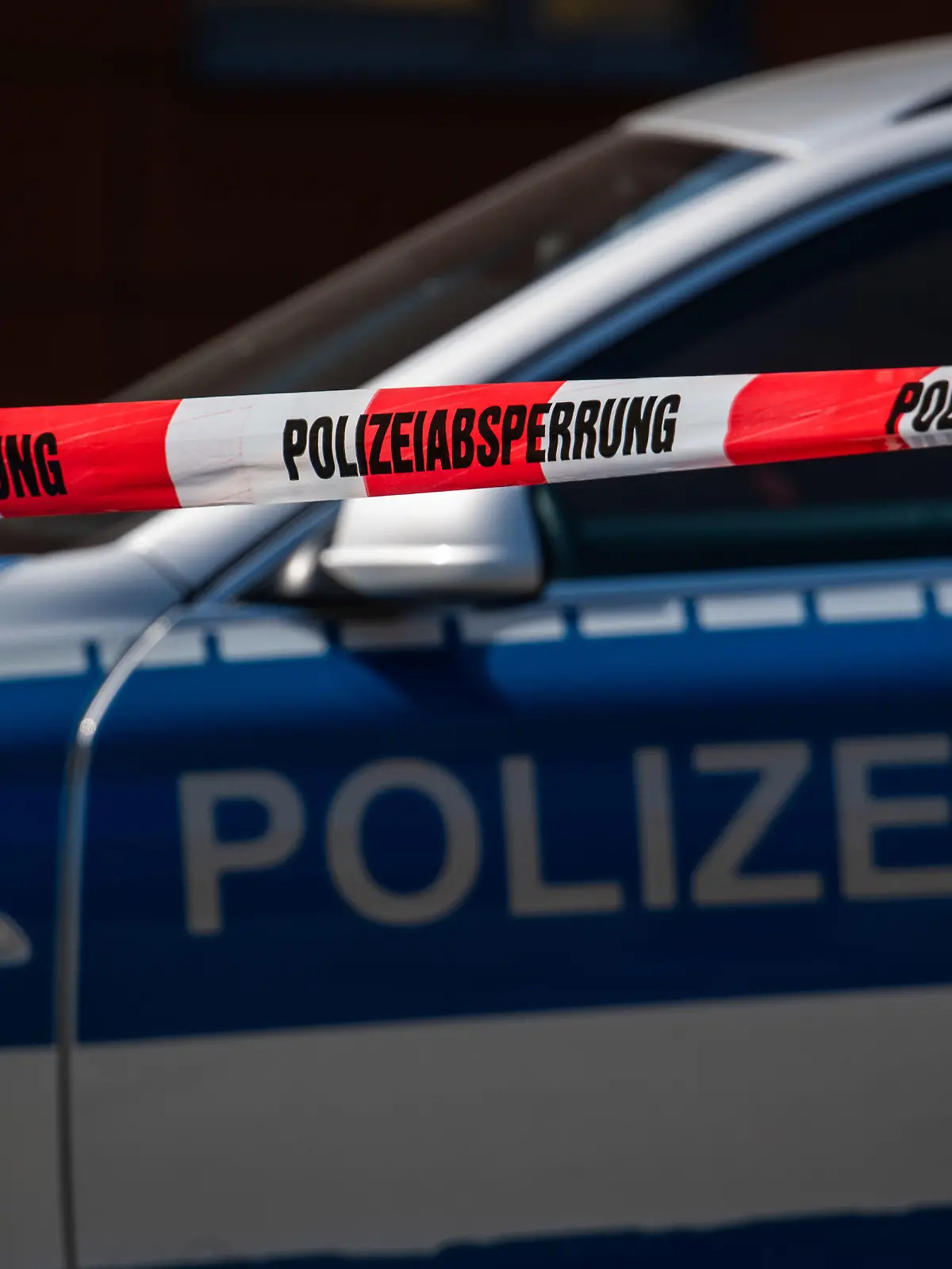 ARCHIV - 07.04.2020, Sachsen, Görlitz: Ein Polizeiauto steht hinter einem Absperrband der Polizei. (Zu dpa: «Rund 250 scharfe Waffen bei mutmaßlich rechten Aktivisten entdeckt»). Foto: Robert Michael/dpa-Zentralbild/dpa +++ dpa-Bildfunk +++