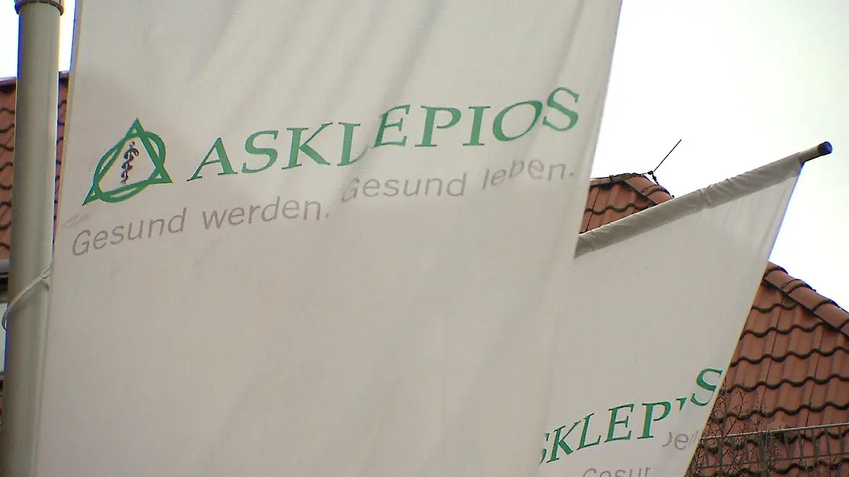 Mehrere Fahnen, auf denen das Logo der Asklepios-Kliniken-Gruppe zu sehen ist.
