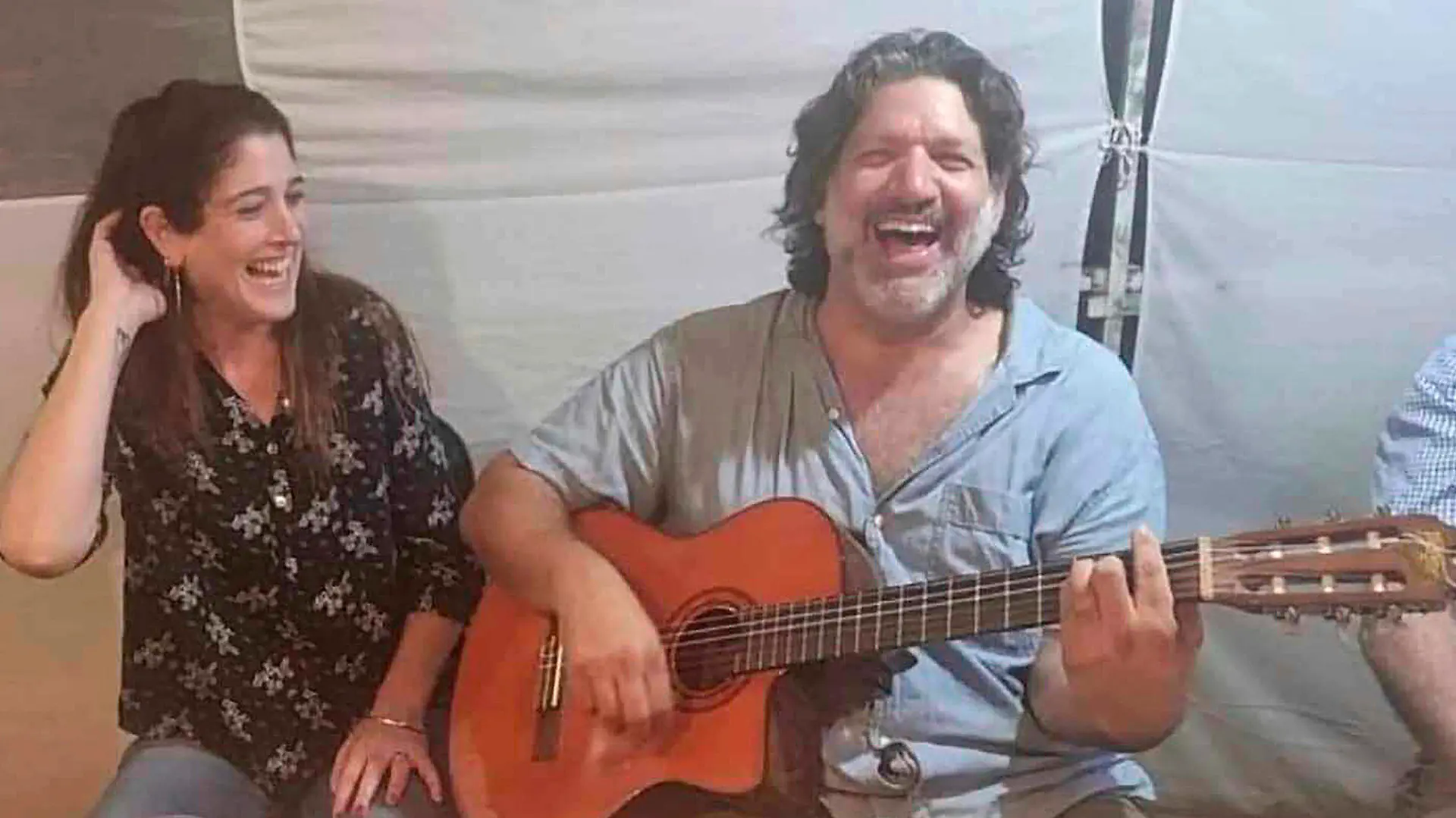 This image provided by Eran Shani shows Shlomi Mathias playing the guitar as his wife, Debbie ‘Shahar’ Mathias, laughs and sings next to him at her 50th birthday party on Oct. 1, 2023, in Lehavim, Israel. They both died days later while protecting their 16-year-old son, Rotem Mathias, from Hamas fighters who attacked their kibbutz in Israel near the border with Gaza on Oct. 7, 2023. (Eran Shani via AP)