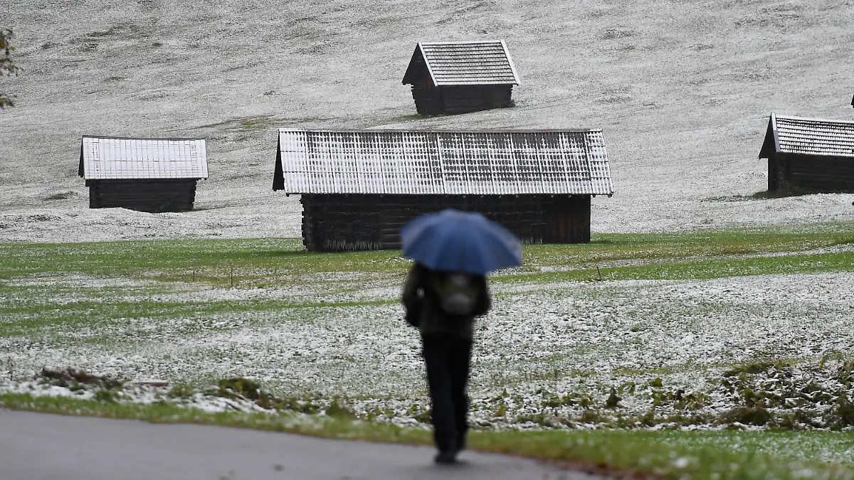 26.09.2020, Bayern, Krün: Ein Mann geht in einem Tal im oberbayerischen Landkreis Garmisch-Partenkirchen spazieren, wo nach einem Temperatursturz der erste Schnee in diesem Herbst gefallen ist. Foto: Angelika Warmuth/dpa +++ dpa-Bildfunk +++