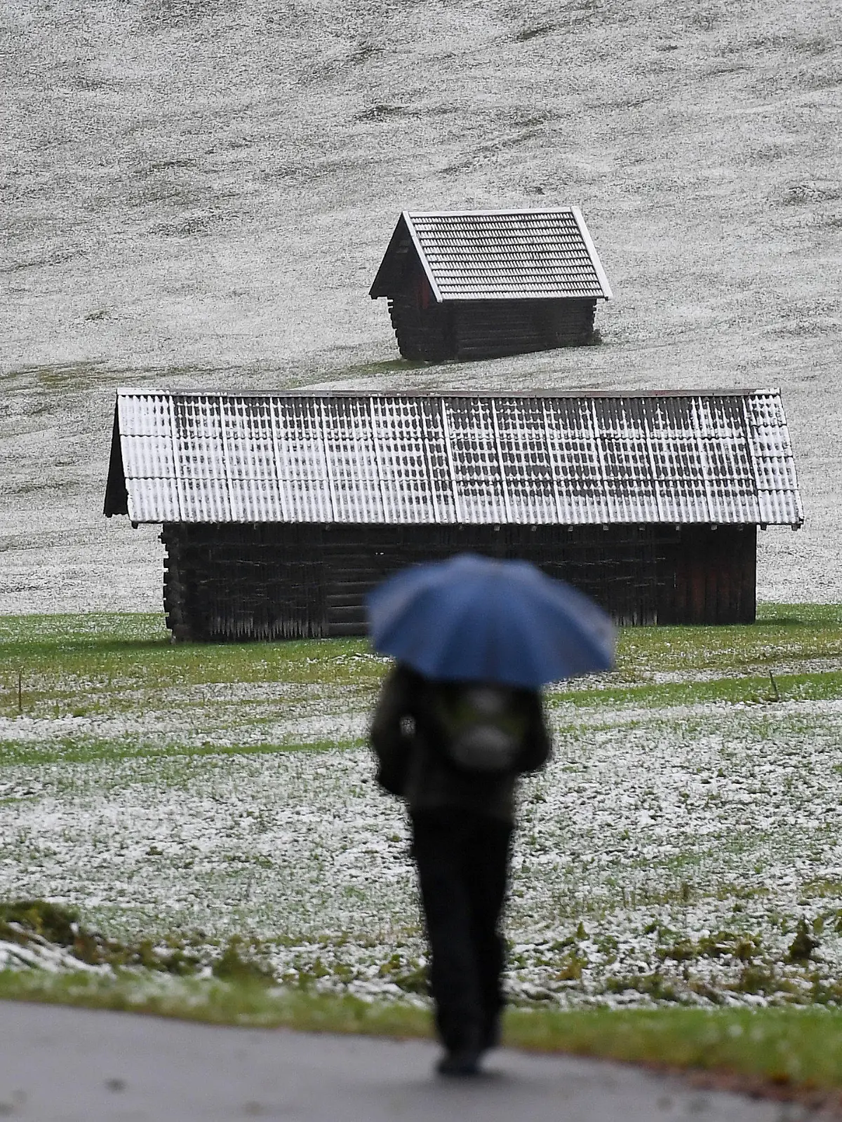 26.09.2020, Bayern, Krün: Ein Mann geht in einem Tal im oberbayerischen Landkreis Garmisch-Partenkirchen spazieren, wo nach einem Temperatursturz der erste Schnee in diesem Herbst gefallen ist. Foto: Angelika Warmuth/dpa +++ dpa-Bildfunk +++