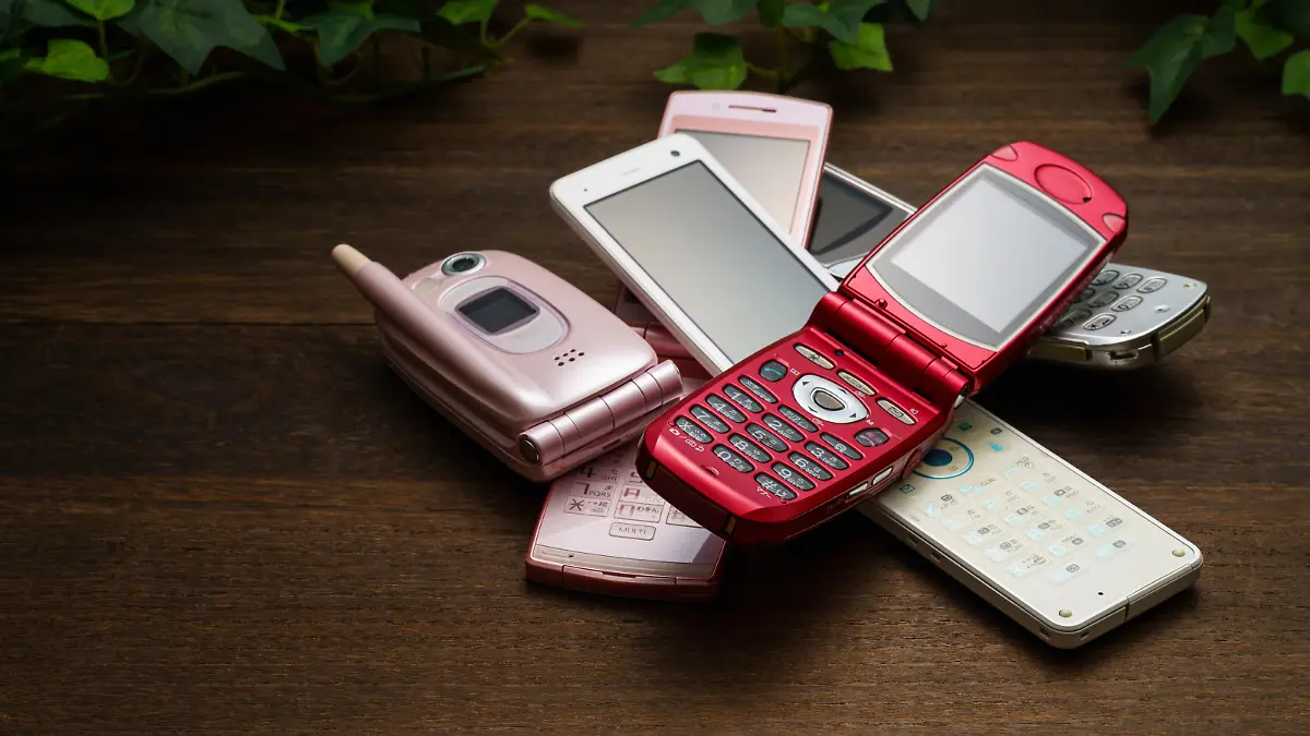 Old used cell phone on white background