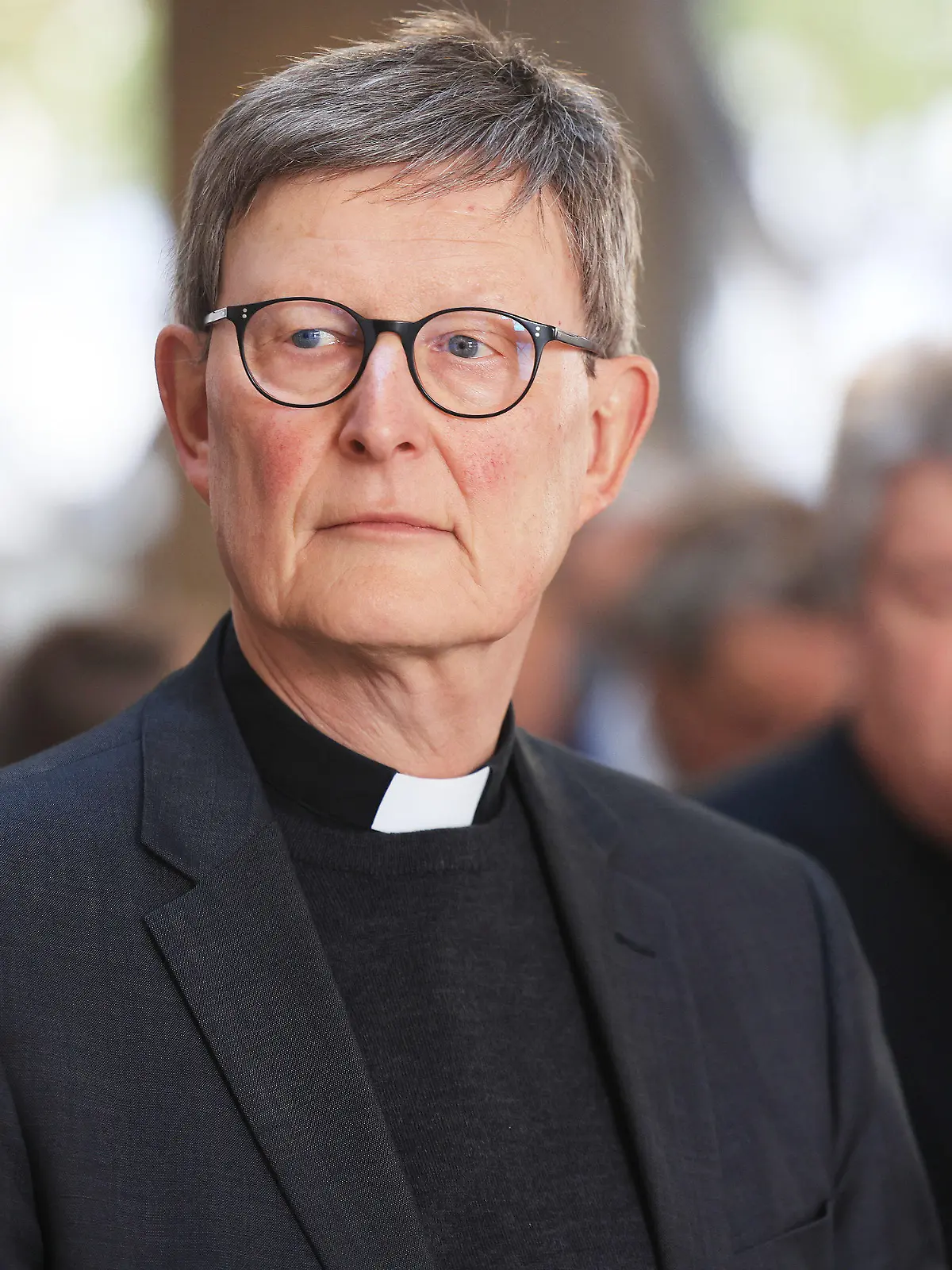 24.10.2022, Nordrhein-Westfalen, Köln: Rainer Maria Woelki, Kardinal von Köln, verfolgt nach der Besichtigung der Restaurierungsarbeiten der Notre-Dame-Fenster die Reden. Seit Ostern werden in der Kölner Dombauhütte vier Fenster aus der durch einen Brand verwüsteten Pariser Kathedrale Notre Dame restauriert. (Zu dpa/lnw:"Kölner Dombauhütte restauriert Notre-Dame-Fenster") Foto: Oliver Berg/dpa +++ dpa-Bildfunk +++
