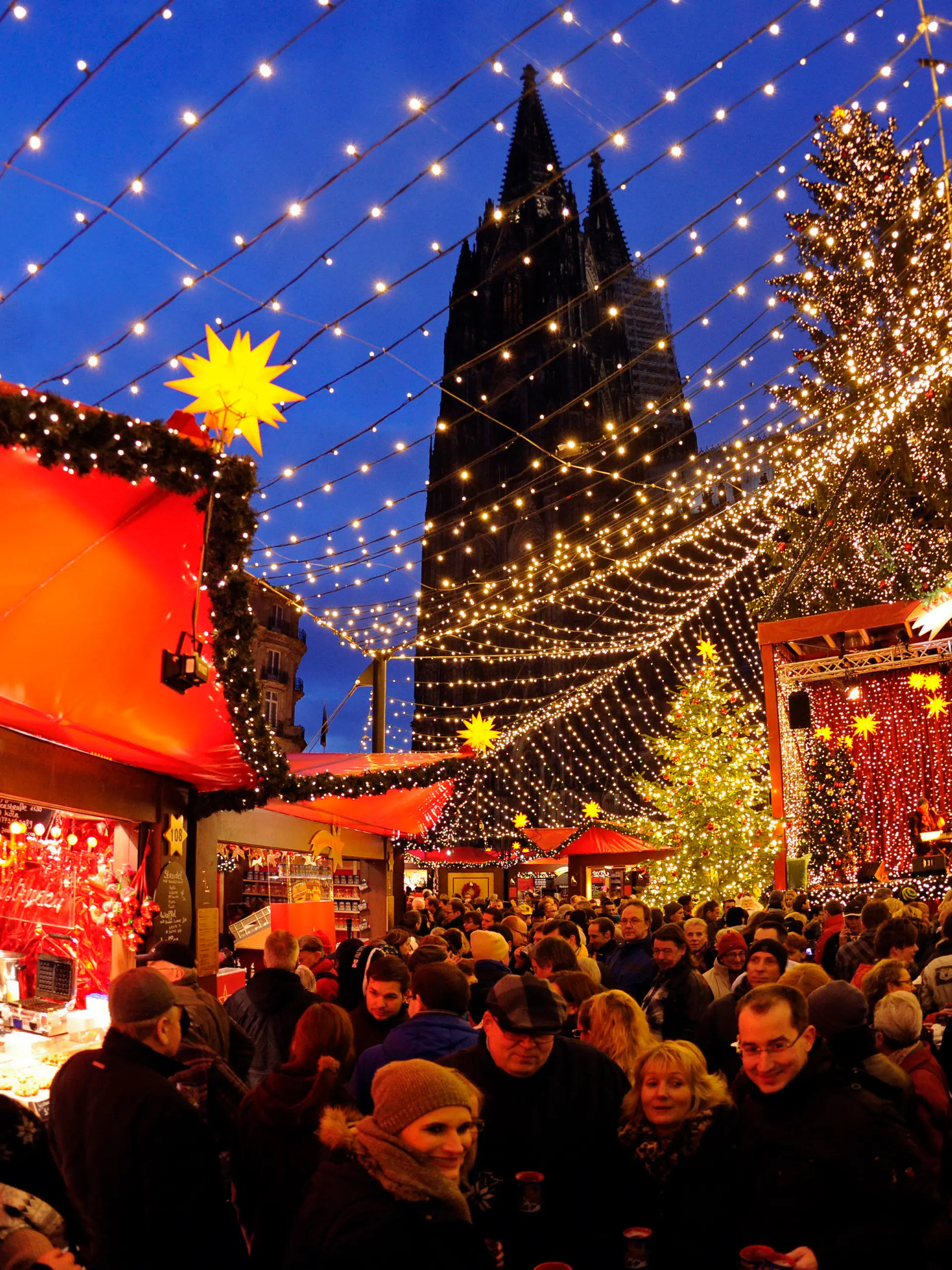 ARCHIV - Besucher gehen am 30.11.2012 über den Weihnachtsmarkt vor dem Dom in Köln (Nordrhein-Westfalen). Der größte Baum, zauberhafte Lichtspiele, romantisches Flair: Die ersten Weihnachtsmärkte in Nordrhein-Westfalen eröffnen am 21.11.2013, die Organisatoren rechnen mit Millionen Besuchern.Foto: Marius Becker/dpa (zu dpa-KORR: "Weihnachtsmärkte eröffnen - NRW rechnet mit Millionen an Besuchern" vom 20.11.2013) +++(c) dpa - Bildfunk+++
