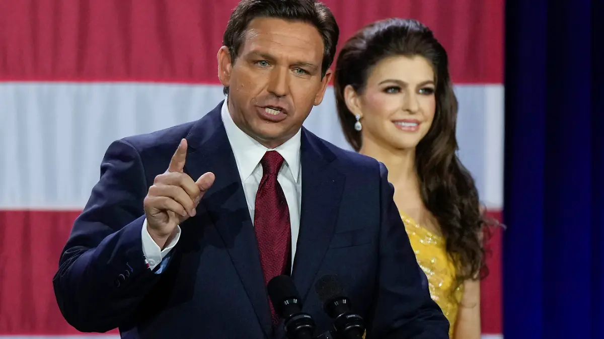 09.11.2022, USA, Tampa: Der amtierende republikanische Gouverneur von Florida, Ron DeSantis (l), spricht auf einer Wahlparty zu seinen Anhängern, nachdem er das Rennen um die Wiederwahl in Tampa, Florida, gewonnen hat, während seine Frau Casey zuhört. Foto: Rebecca Blackwell/AP/dpa +++ dpa-Bildfunk +++