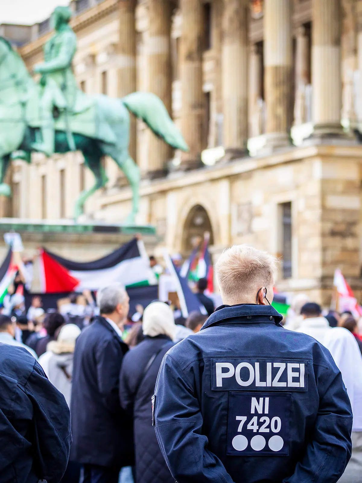 14.10.2023, Niedersachsen, Braunschweig: Polizisten beobachten Demonstranten, die an einer pro-palästinensischen Demonstration auf dem Schlossplatz teilnehmen. Nach dem Terrorangriff der Hamas auf Israel kam es deutschlandweit zu zahlreichen Reaktionen. Foto: Moritz Frankenberg/dpa +++ dpa-Bildfunk +++