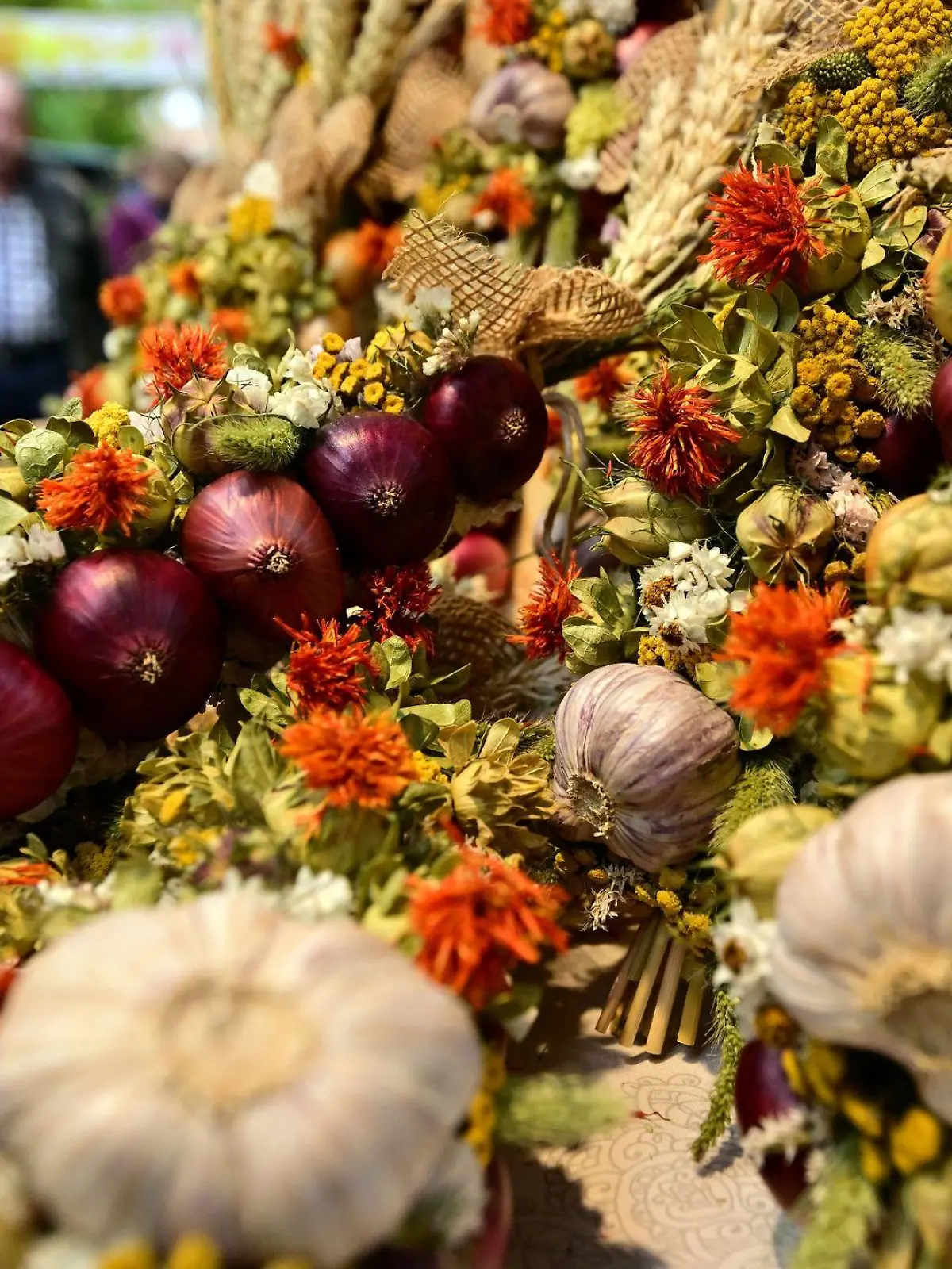 An einem Marktstand beim 370. Weimarer Zwiebelmarkt liegen bunte Zöpfe aus Ziebeln und Knoblauchkollen zum Verkauf.