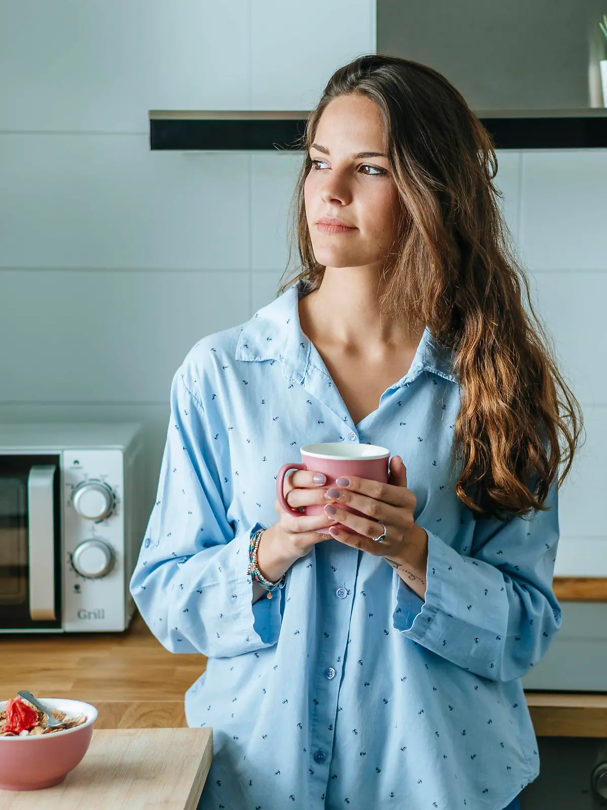 Portrait of young woman wearing pyjama in kitchen at home holding cup of coffee model released Symbolfoto property released PUBLICATIONxINxGERxSUIxAUTxHUNxONLY KIJF02534