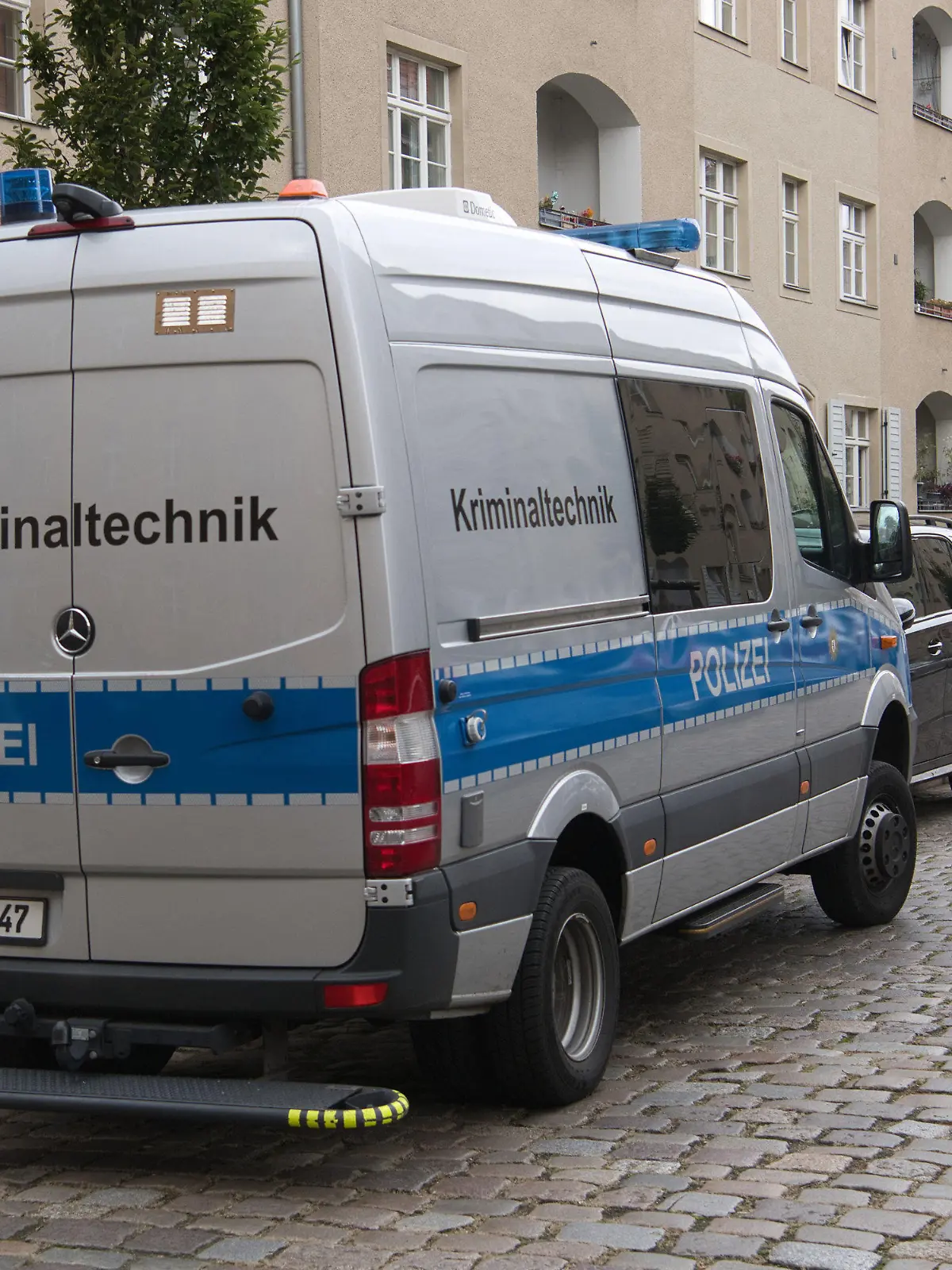 03.01.2023, Berlin: Ein Einsatzfahrzeug der Kriminaltechnik der Polizei steht vor einer Häuserzeile an der Kinzerallee im Berliner Stadtteil Köpenick. Dort wurden die Leichen einer Frau und eines Kindes in einer Wohnung gefunden. Eine Mordkommission hat die Ermittlungen übernommen. Foto: Paul Zinken/dpa +++ dpa-Bildfunk +++