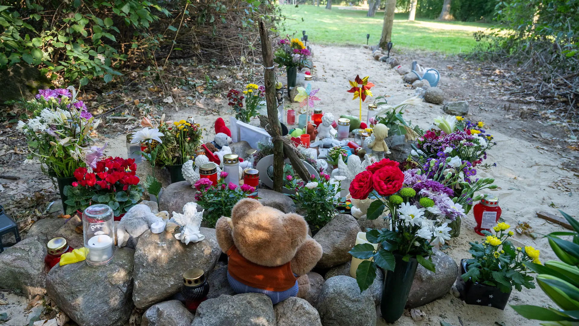 26.09.2023, Mecklenburg-Vorpommern, Pragsdorf: Nahe der Stelle in Pragsdorf, wo ein Sechsjähriger am 14.09.2023 mit Stichverletzungen gefunden wurde, an denen er später verstarb, steht ein buntes Kreuz und liegen Plüschtiere znn Blumen. Nach dem gewaltsamen Tod eines sechsjährigen Jungen im Südosten Mecklenburg-Vorpommerns hat die Polizei einen 14-jährigen Tatverdächtigen festgenommen. Das teilte die Polizei am Dienstag mit. Die Leiche des Sechsjährigen war am 14. September in Pragsdorf bei Neubrandenburg gefunden worden. Foto: Stefan Sauer/dpa +++ dpa-Bildfunk +++