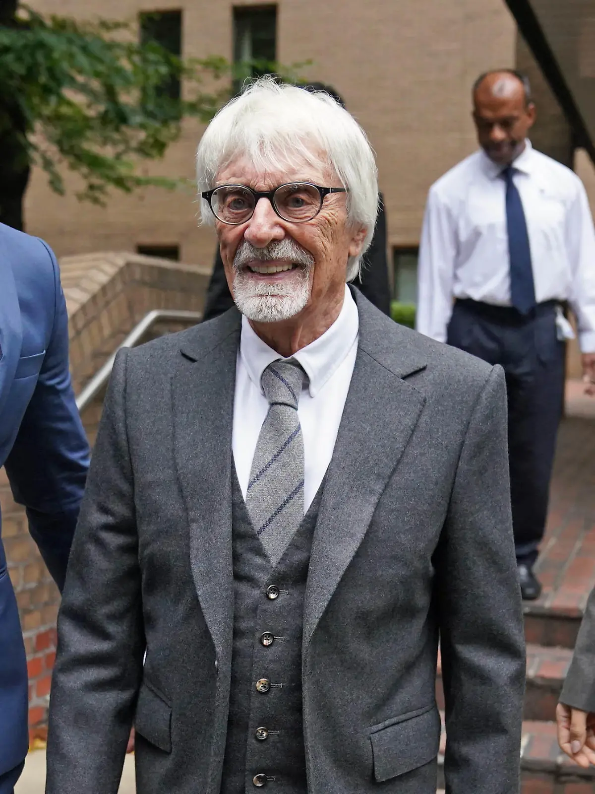 04.10.2022, Großbritannien, London: Bernie Ecclestone (M), ehemaliger Geschäftsführer der Formel-1, verlässt das Southwark Crown Court in London. Ecclestone wird Betrug vorgeworfen. Er soll zu einem Auslandsvermögen über 400 Million Pfund (ca. 472 Millionen Euro) falsche Angaben gemacht haben. Foto: Victoria Jones/PA Wire/dpa +++ dpa-Bildfunk +++