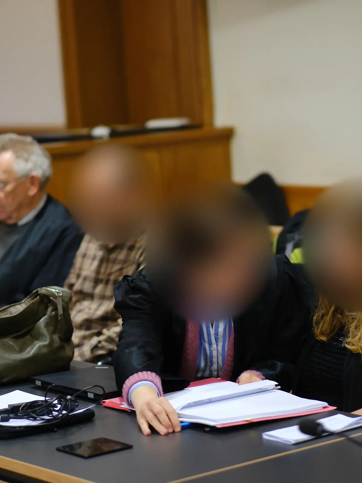 09.10.2023, Niedersachsen, Oldenburg: Die Angeklagten Jens R. (2.v.l) und Marion S. (r) sowie ihre beiden Rechtsanwälte sitzen im Saal 1 des Landgerichts Oldenburg. Wegen schwerer Körperverletzung an ihrem Kind müssen sich eine Mutter und ein Vater vor dem Landgericht verantworten. Der Vater des Kindes soll dieses Anfang 2019 in Delmenhorst im Rahmen von Wiederbelebungsversuchen derart stark geschüttelt haben, dass dieses Einblutungen im Schädel erlitt, welche zu einem Behinderungsgrad von 70 Prozent geführt haben sollen. Die angeklagte Mutter des Kindes soll dieses Monate später erneut heftig geschüttelt haben. Foto: Markus Hibbeler/dpa - ACHTUNG: Person(en) wurde(n) aus rechtlichen Gründen gepixelt +++ dpa-Bildfunk +++