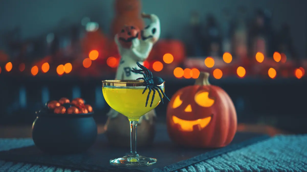 Halloween time. Vibrant colored drinks with cauldron of candy