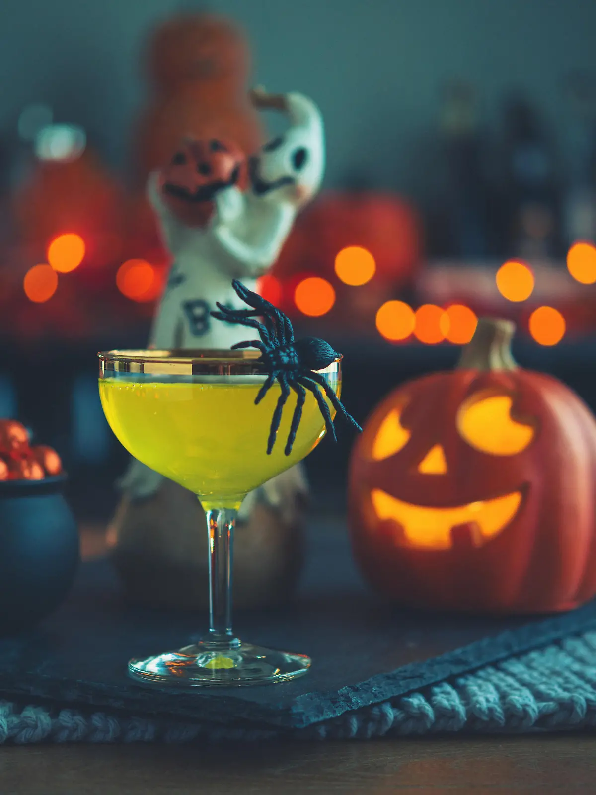 Halloween time. Vibrant colored drinks with cauldron of candy