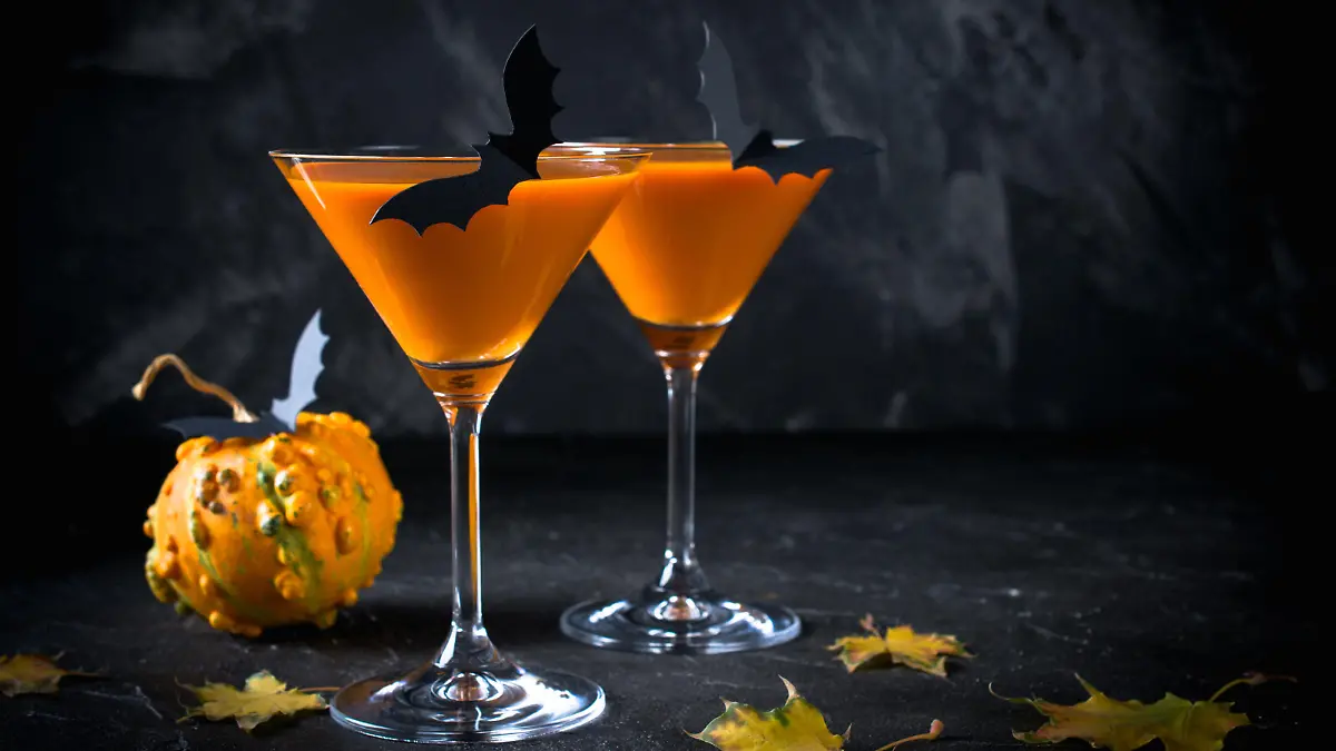 Halloween pumpkin orange cocktails. Festive drink. Halloween party. Funny Pumpkin with holiday decorations