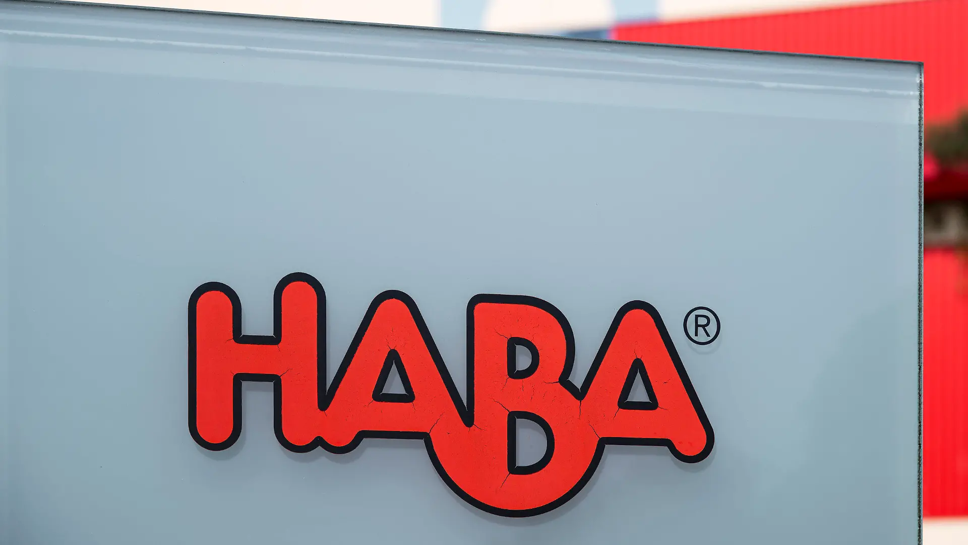 12.09.2023, Bayern, Bad Rodach: Das Haba Logo steht auf einem Hinweisschild vor dem Haba Werk der Haba Familygroup. Der Spielzeughersteller Haba meldet Insolvenz in Eigenregie an. Foto: Daniel Vogl/dpa +++ dpa-Bildfunk +++