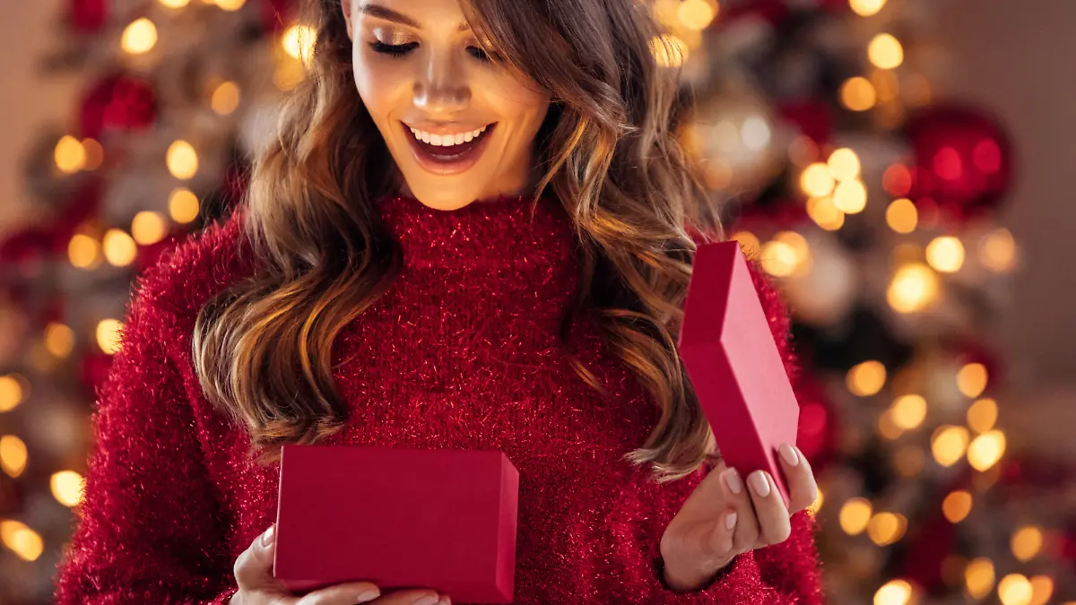 Beautiful girl sitting in a cozy atmosphere near the Christmas tree