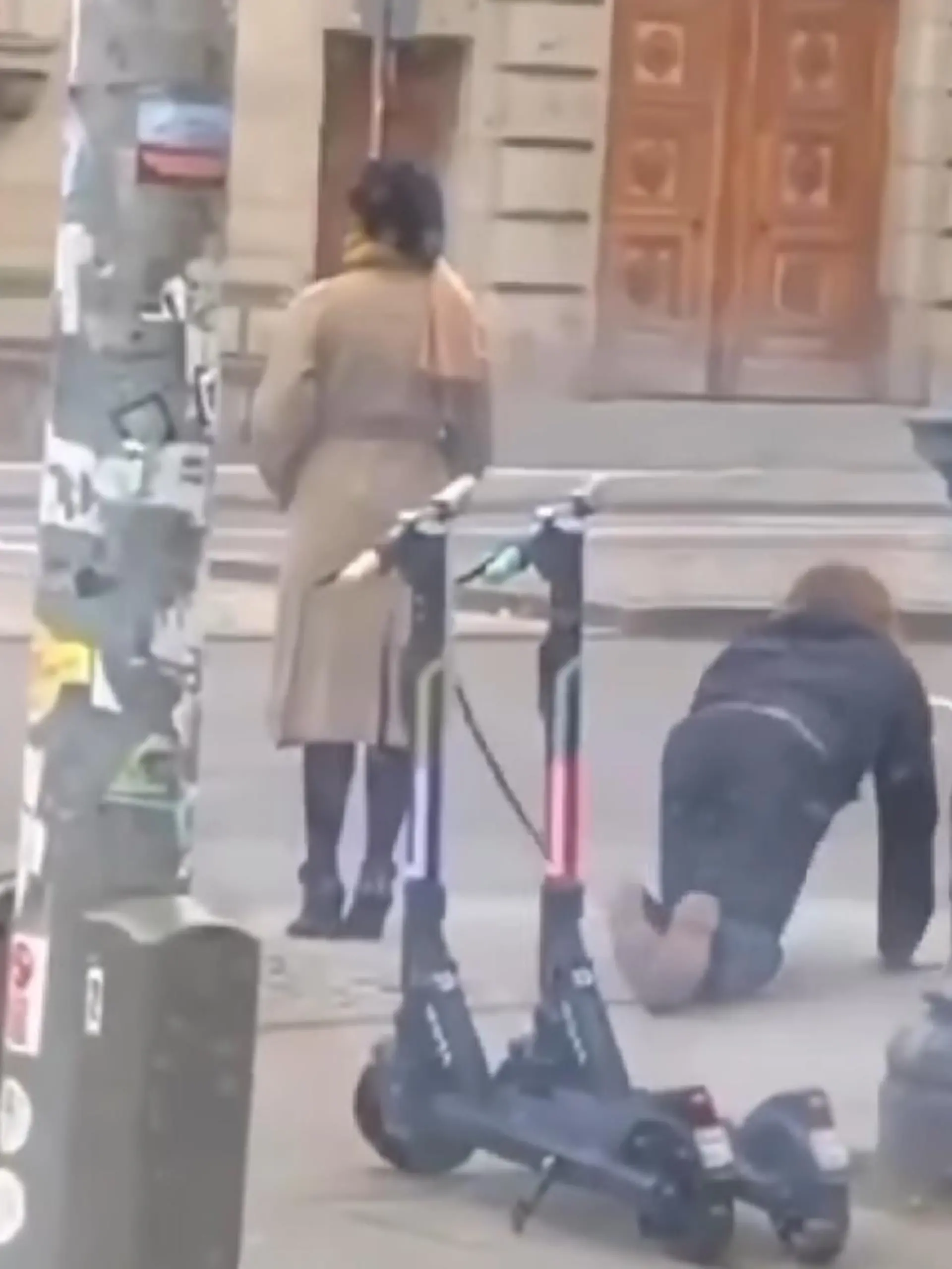 Eine Frau und ein Mann an einer Hundeleine gehen durch München.
