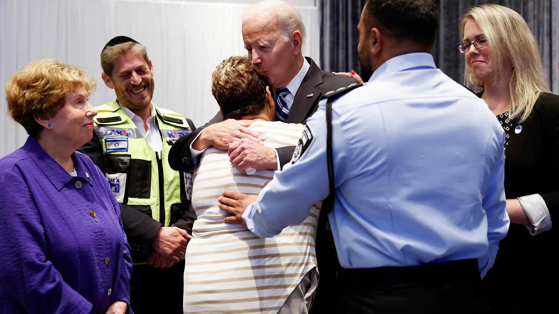 U.S. President Joe Biden embraces Rachel Edri, flanked by her son Evyatar Edri, during a meeting with Israeli first responders, family members and other citizens directly impacted by the October 7th attack on Israel by Hamas, in Tel Aviv, Israel, October 18, 2023. REUTERS/Evelyn Hockstein