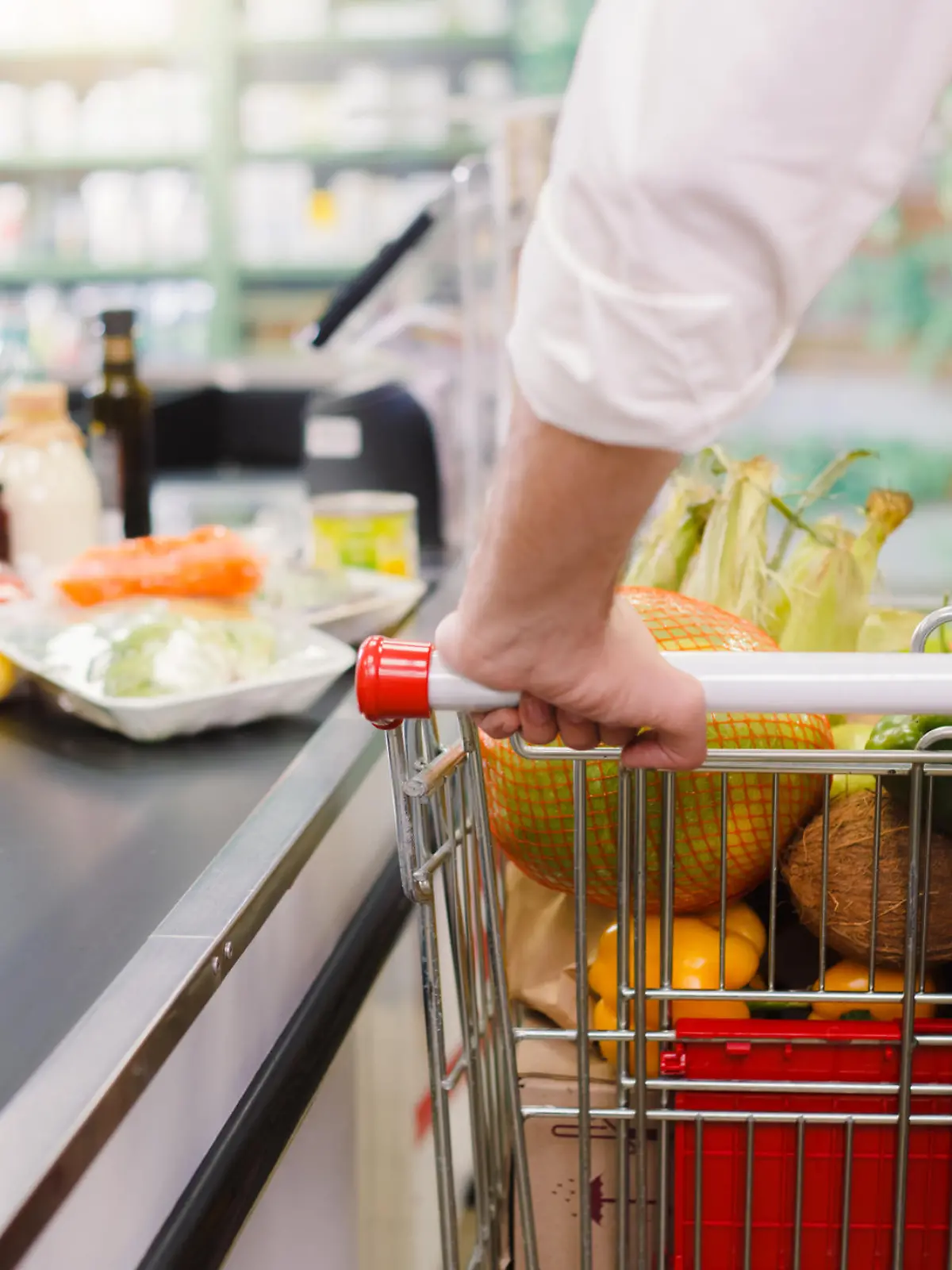 Ein Mann steht an der Supermarkt-Kasse.