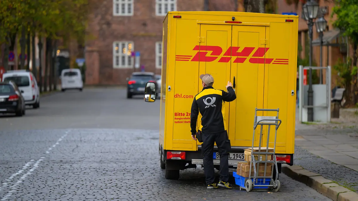 03.11.2022, Niedersachsen, Lüneburg: Ein Zusteller entlädt ein Fahrzeug von DHL in der Innenstadt. Foto: Philipp Schulze/dpa +++ dpa-Bildfunk +++