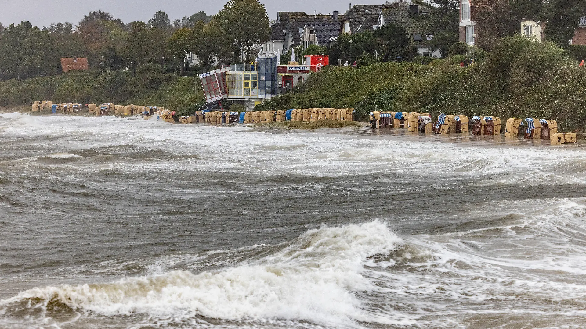 20.10.2023, Schleswig-Holstein, Kiel: Ostseewellen überfluten die am Strand in Schilksee aufgestellten Strandkörbe. In der Kieler und Lübecker Bucht wird nach der Vorhersage des Bundesamtes für Seeschifffahrt und Hydrographie (BSH) eine schwere Sturmflut erwartet. In der Flensburger Förde können Wasserstände bis 2,0 m über dem mittleren Wasserstand erreicht werden, bei Rügen bis zu 1,30 m über dem mittleren Wasserstand. Foto: Axel Heimken/dpa +++ dpa-Bildfunk +++