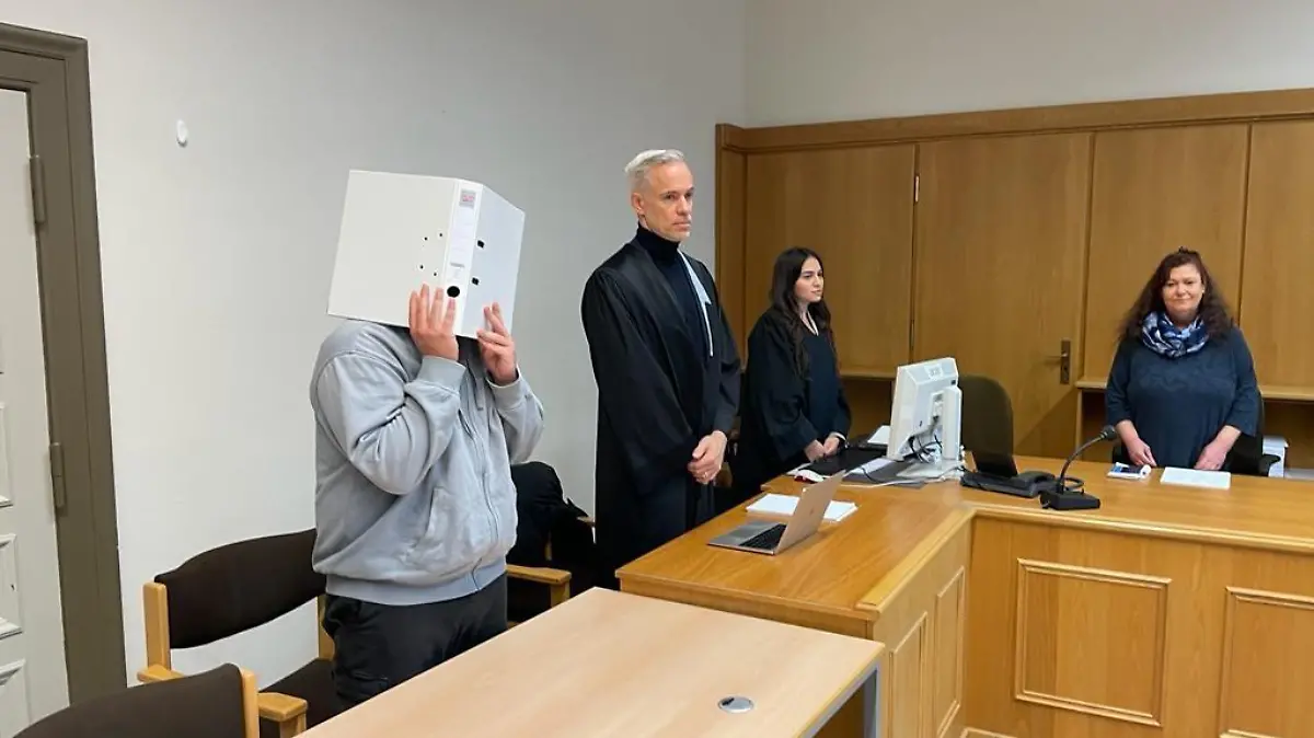 Der Angeklagte Sergen Ö. versteckt sein Gesicht beim heutigen Prozessauftakt hinter einem Ordner.