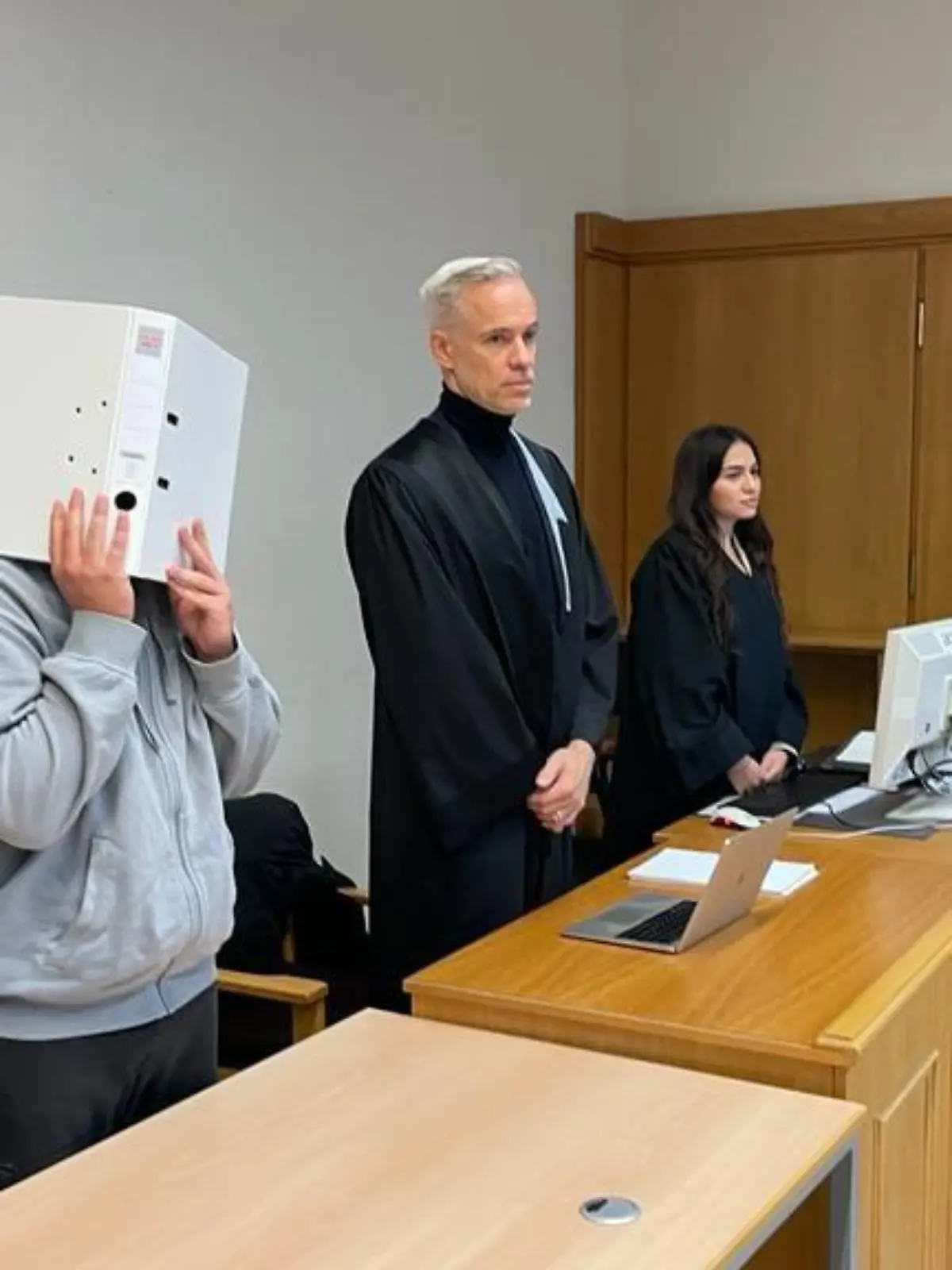 Der Angeklagte Sergen Ö. versteckt sein Gesicht beim heutigen Prozessauftakt hinter einem Ordner.