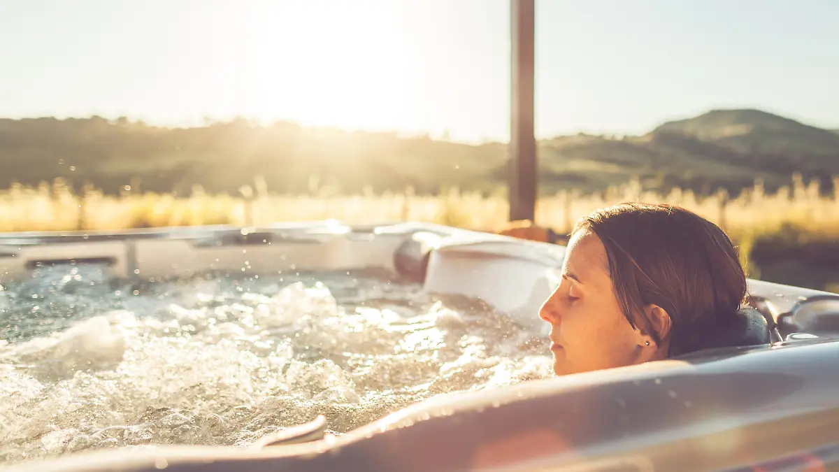 Woman in whirlpool hot tub at sunset