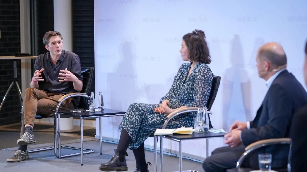 Henning Jeschke von der letzten Generation bei einer Podiumsdiskussion mit Bundeskanzler Olaf Scholz.