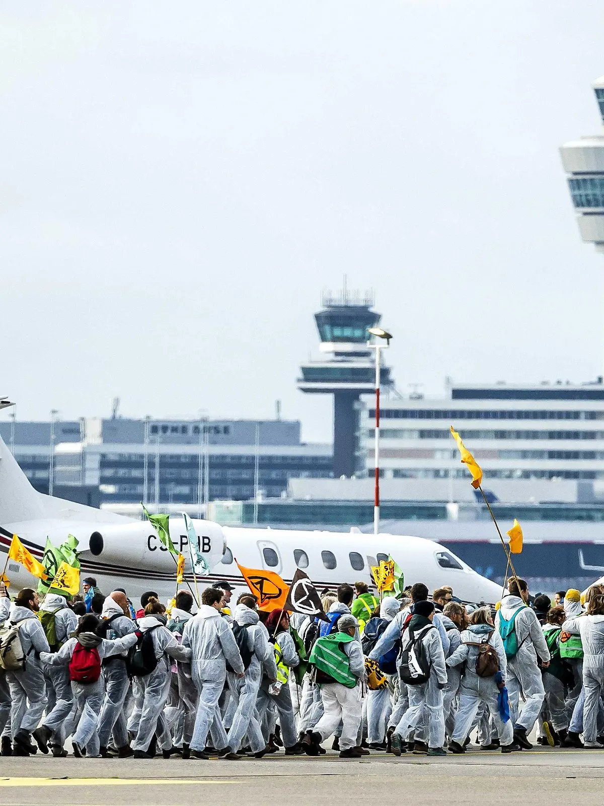 dpatopbilder - 05.11.2022, Niederlande, Amsterdam: Aktivisten verschiedener Umweltvereine führen die Protestaktion «SOS für das Klima» auf dem Flughafengelände vom Flughafen Schiphol durch. Unter anderem haben sich Milieudefensie, Extinction Rebellion und Greenpeace dem Protest angeschlossen. Foto: Remko De Waal/ANP/dpa +++ dpa-Bildfunk +++