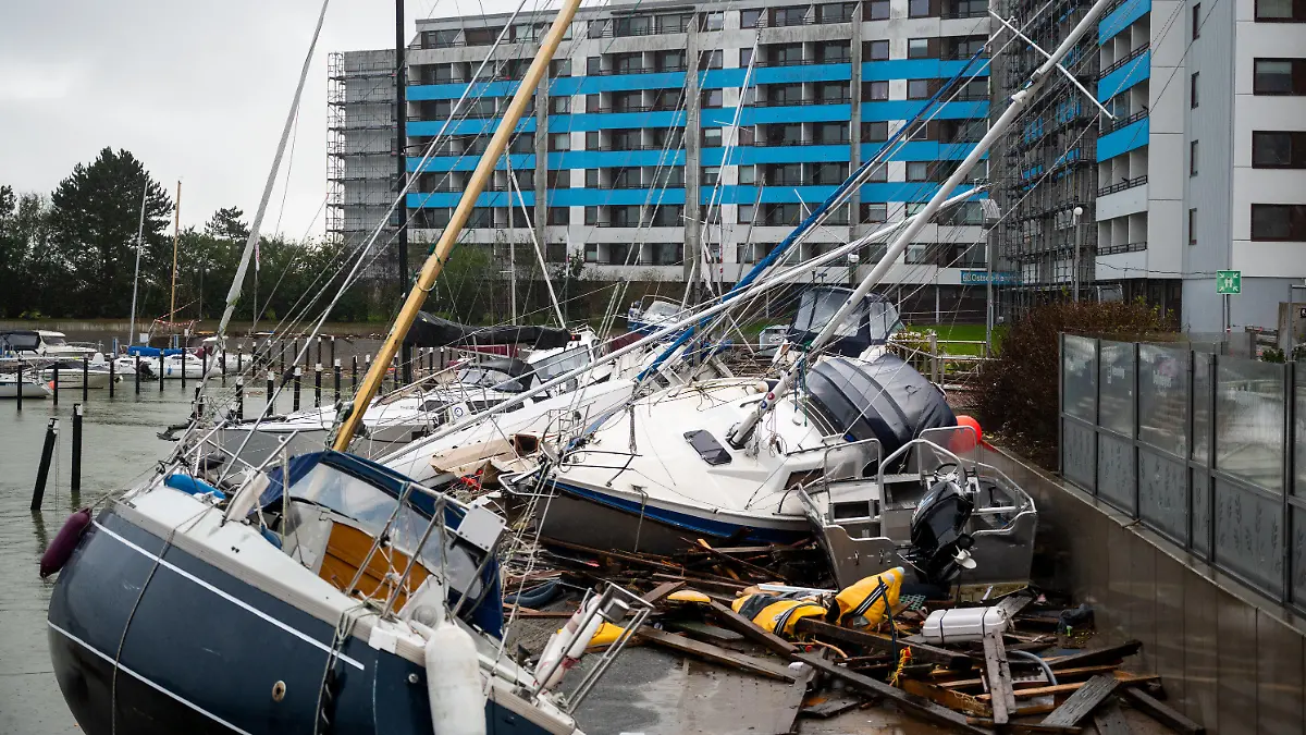 21.10.2023, Schleswig-Holstein, Damp: Beschädigte Schiffe liegen im Hafen nach einer Sturmflut auf einem Anleger. Foto: Daniel Bockwoldt/dpa +++ dpa-Bildfunk +++