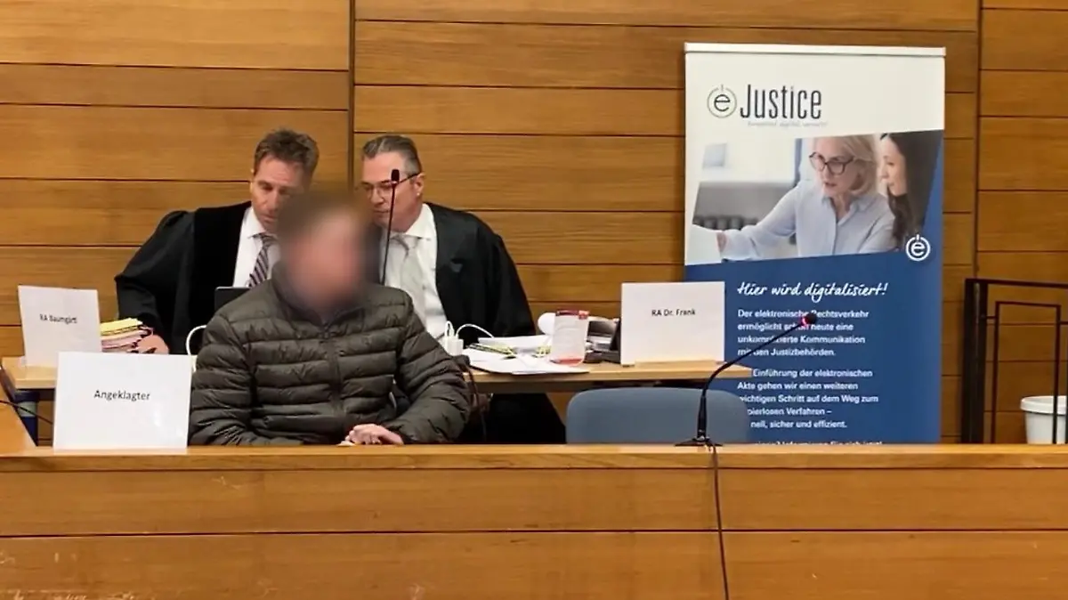 Der Angeklagte sitzt auf der Anklagebank. Dahinter seine Verteidiger.