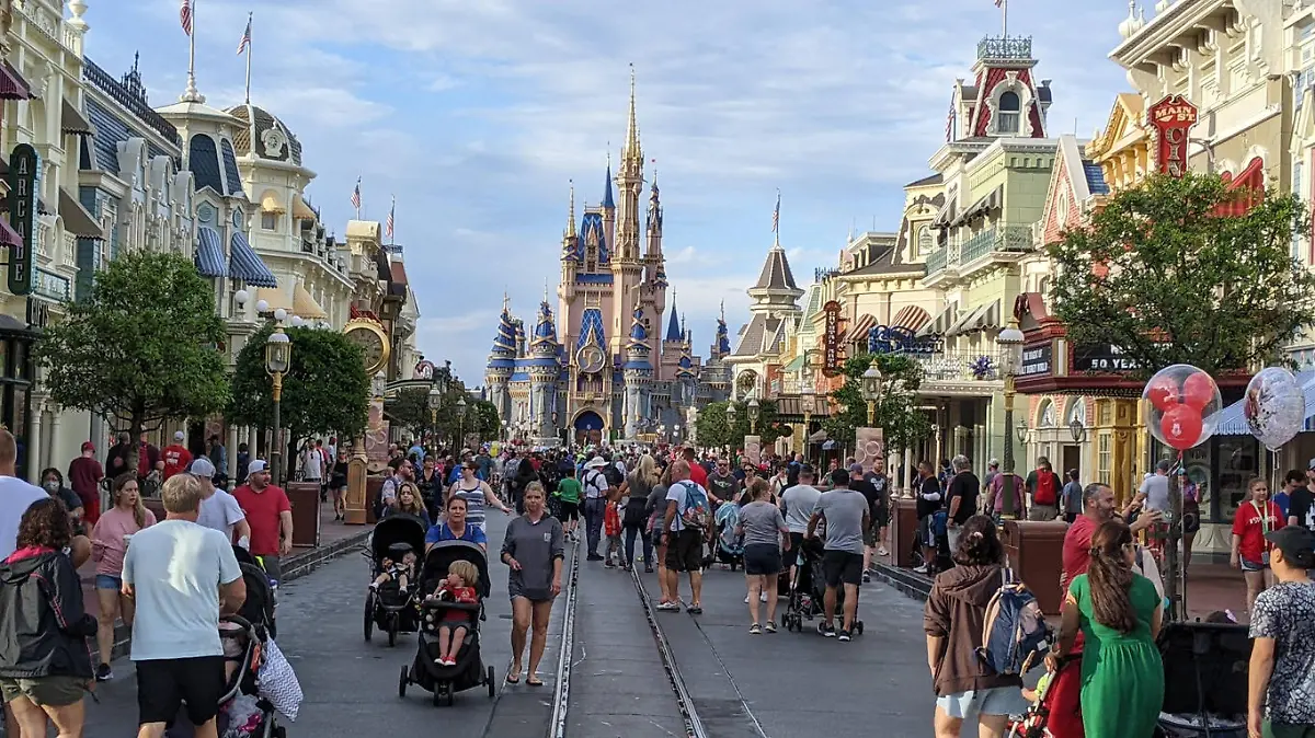 Visitors on Main Street, Magic Kingdom,  Walt Disney World, Orlando, Florida. Cinderella's Castle at rear is decorated for the 50th anniversary of the parks's opening.