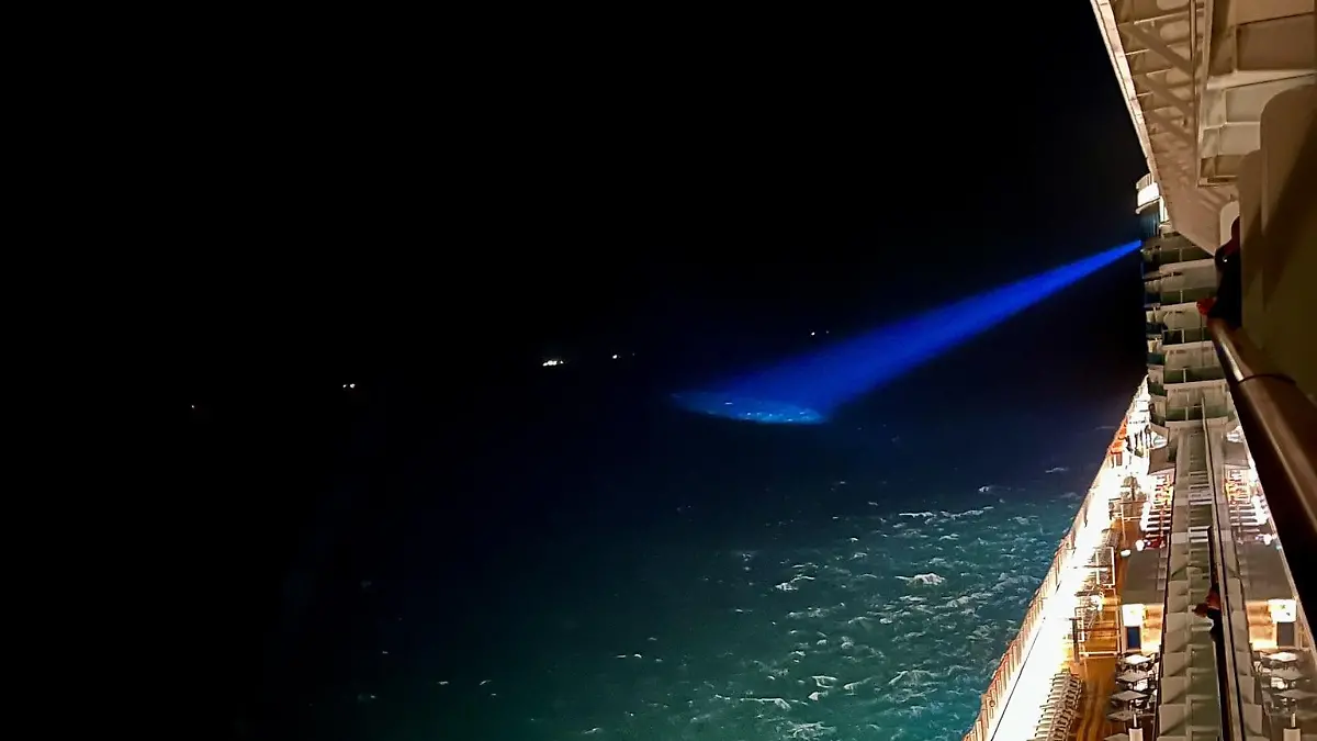 HANDOUT - 24.10.2023, ---, Nordsee: Ein Suchscheinwerfer des P&O-Kreuzfahrtschiffs «Iona», sucht das Wasser in der Nähe der Stelle ab, an der das britische Frachtschiff «Verity» nach einer Kollision mit dem Schiff «Polesie» in der Nordsee nahe der deutschen Insel Helgoland gesunken ist. Nach dem Zusammenstoß von zwei Frachtschiffen in der Nordsee beteiligt sich auch ein Kreuzfahrtschiff an der Suche nach den Vermissten. (Bestmögliche Qualität) Foto: Handout/P&O/PA Media/dpa +++ dpa-Bildfunk +++