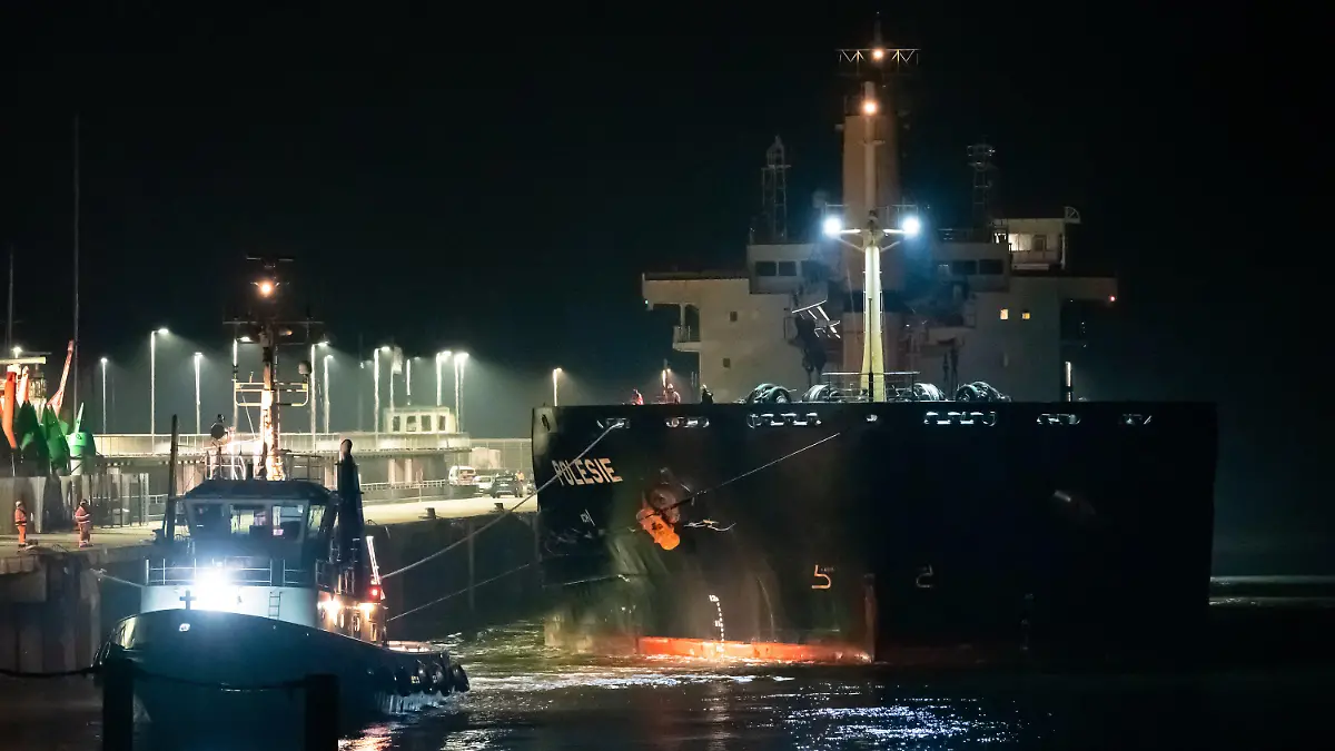 dpatopbilder - 25.10.2023, Niedersachsen, Cuxhaven: Das Frachtschiff «Polesie» wird in der Nacht von zwei Schleppern an den Kai der Seebäderbrücke gezogen. Nach der Kollision von zwei Frachtern auf der Nordsee vor Helgoland sind die vier vermissten Menschen der siebenköpfigen Besatzung noch nicht gefunden worden. Foto: Jonas Walzberg/dpa +++ dpa-Bildfunk +++