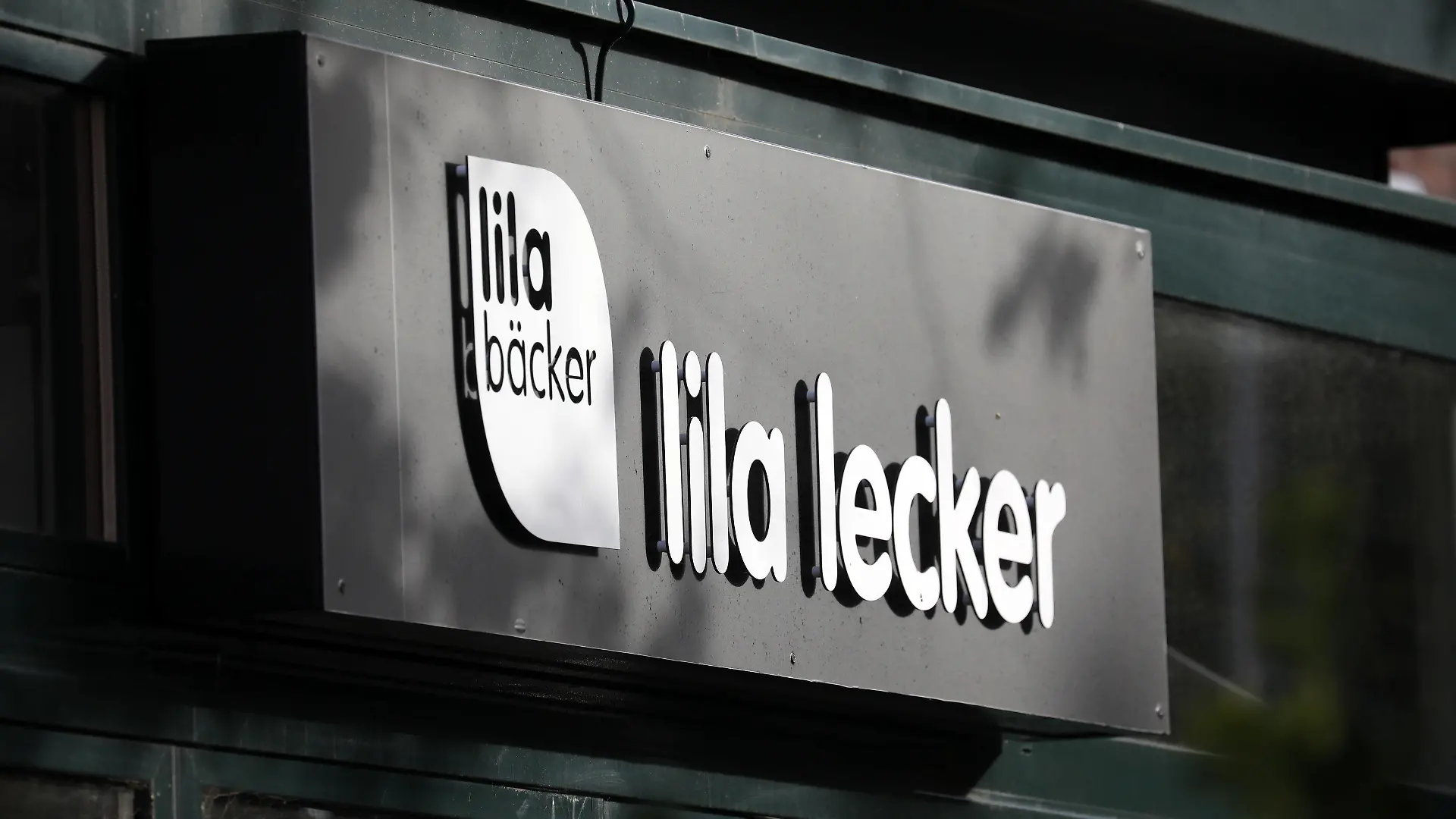 ARCHIV - 29.09.2021, Mecklenburg-Vorpommern, Warnemünde: Das Logo des Unternehmens Lila Bäcker mit dem Schriftzug «lila lecker» an einer Filiale im Ostseebad. Die Backkette Lila Bäcker hat beim Amtsgericht Neubrandenburg Antrag auf Sanierung in Eigenverwaltung gestellt. (zu dpa «Lila Bäcker stellt Antrag auf Sanierung in Eigenverwaltung») Foto: Bernd Wüstneck/dpa-Zentralbild/dpa +++ dpa-Bildfunk +++