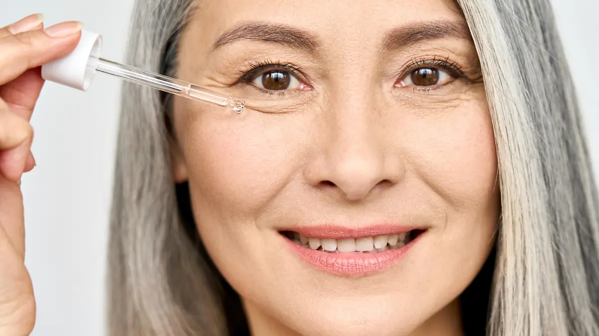 Frau trägt ein Niacinamid-Serum auf.