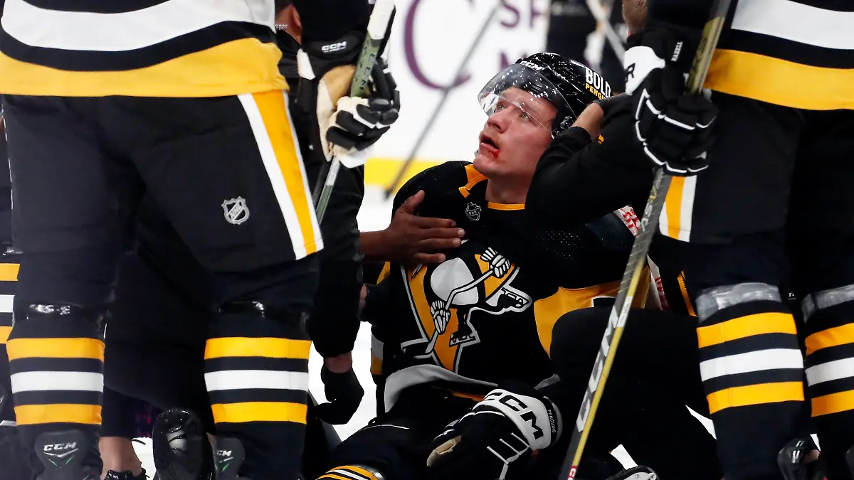 Oct 24, 2023; Pittsburgh, Pennsylvania, USA; Pittsburgh Penguins defenseman John Ludvig (7) is helped into a sitting position after being shaken up on a check against the Dallas Stars during the second period at PPG Paints Arena. Mandatory Credit: Charles LeClaire-USA TODAY Sports