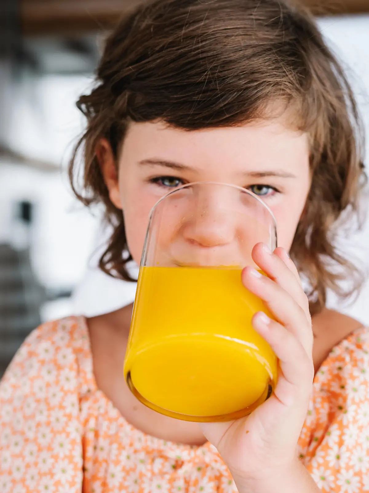 Preschool brown haired girl looking at camera while drinking tasty orange juice from glass in cafeteria HodeiUnzueta_ID936_34706_013 Copyright: xHodeixUnzuetax