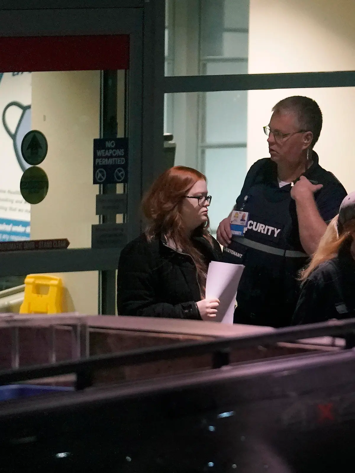 People depart an emergency department entrance at Central Maine Medical Center, past a member of security, behind right, during an active shooter situation, in Lewiston, Maine, Wednesday, Oct. 25, 2023. (AP Photo/Steven Senne)